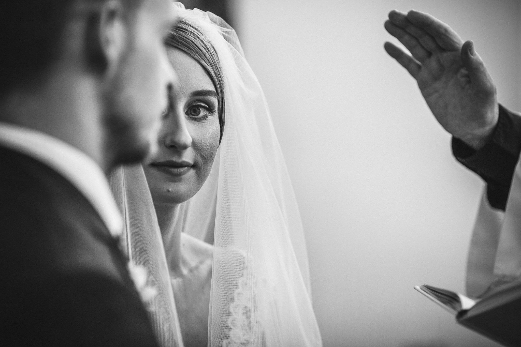 black and white close up of bride during vows
