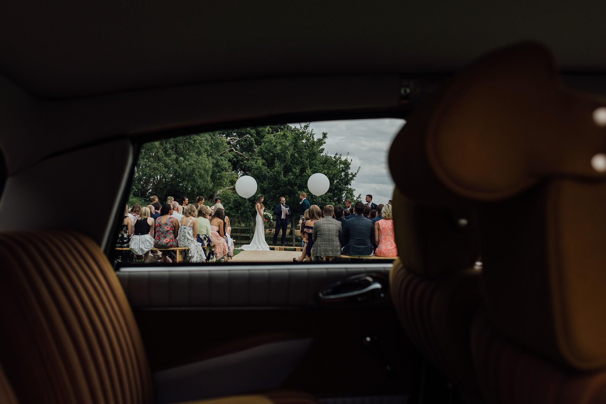 ceremony in a field shot through a car window