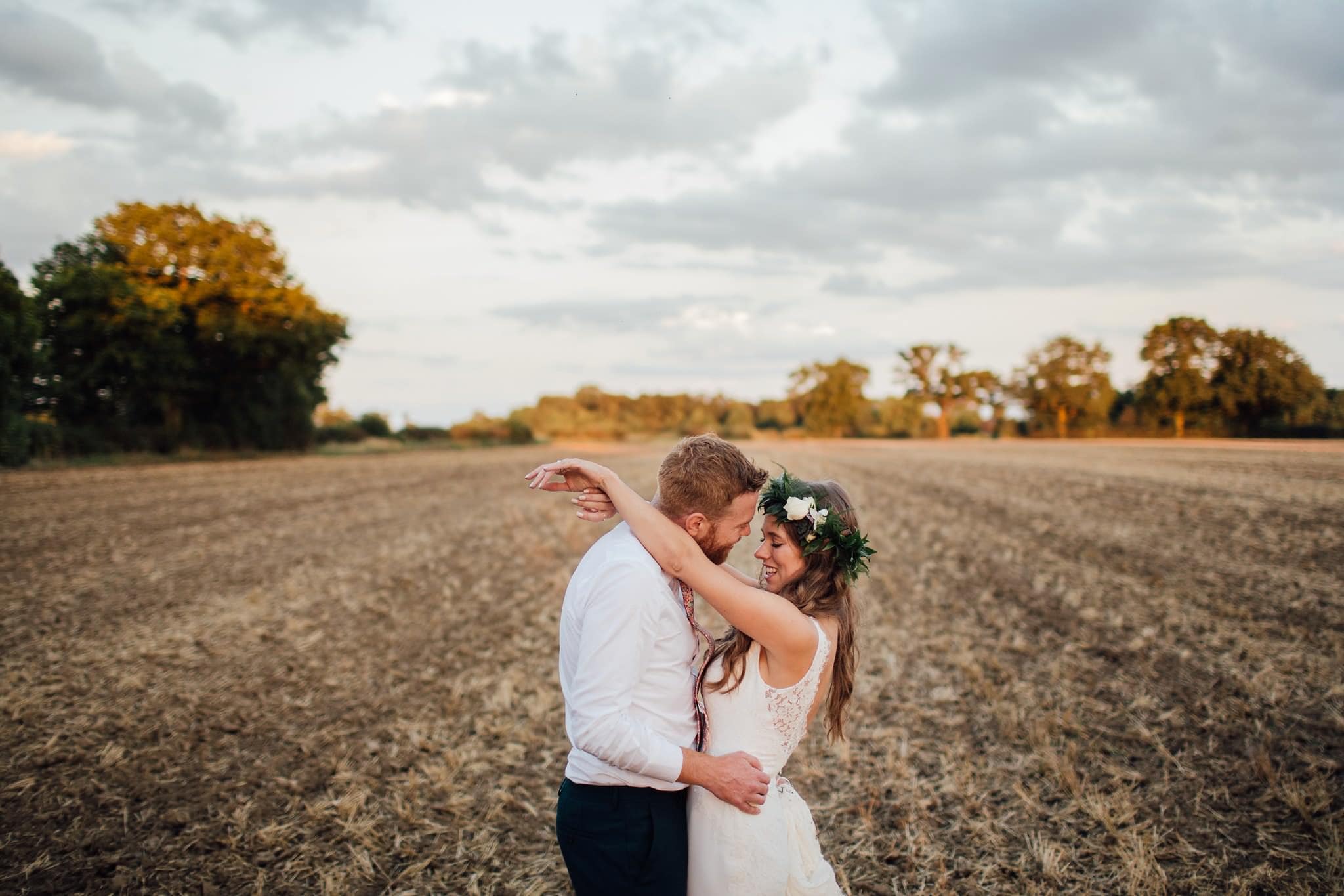 sunset portrait of bride and groom in a field