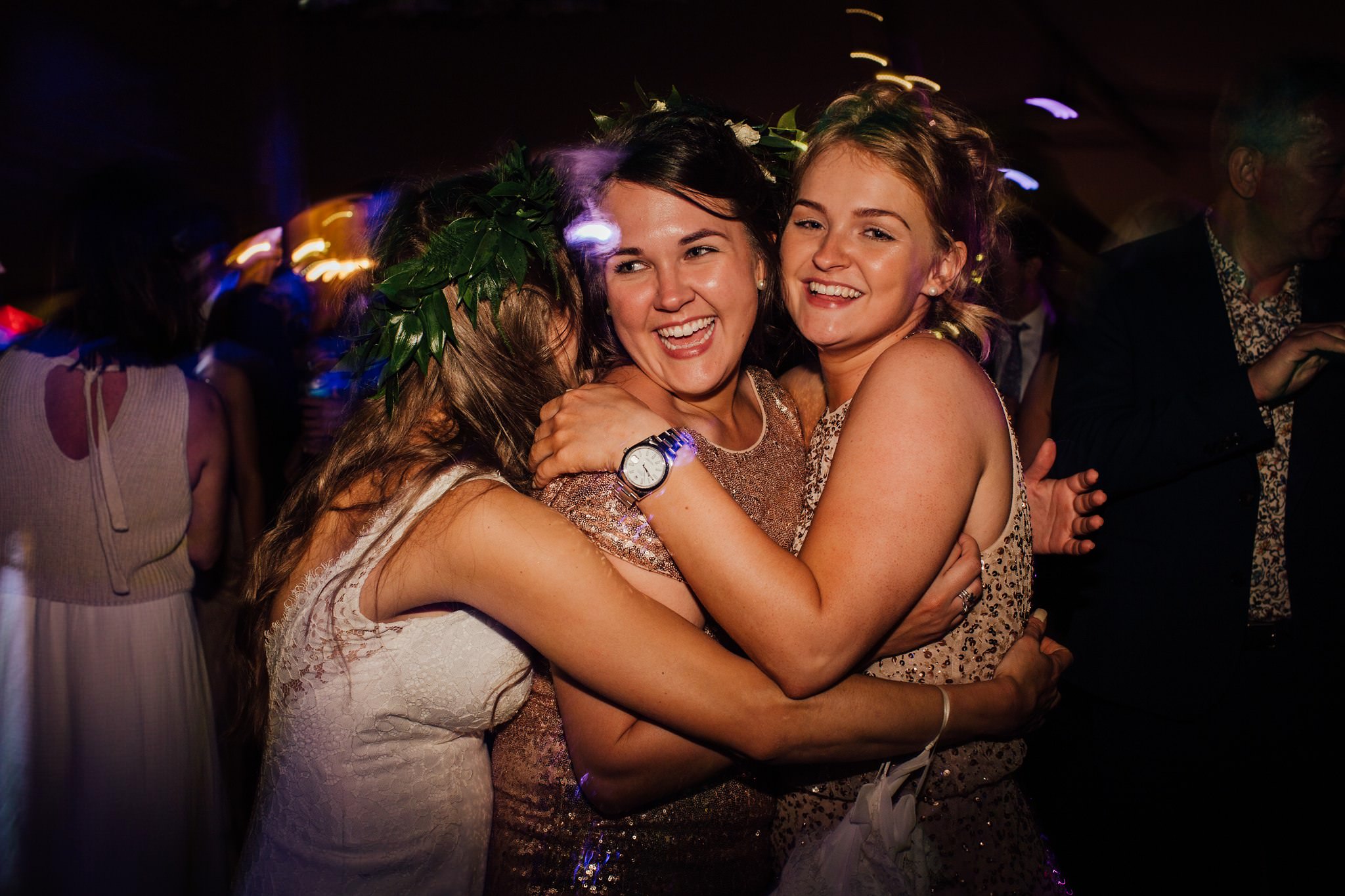 bride and bridesmaids hugging and dancing