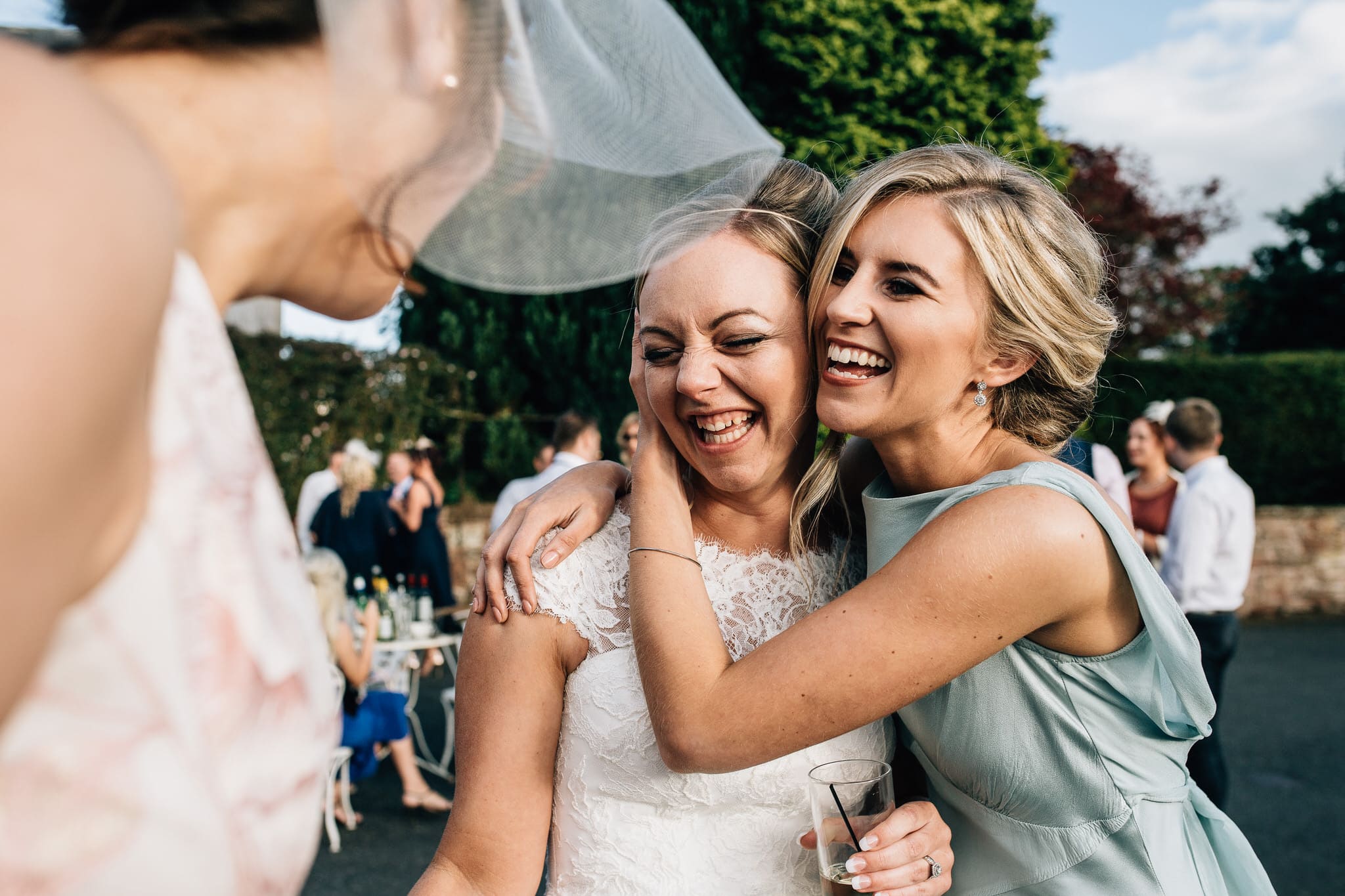 bridesmaid hugging bride happy