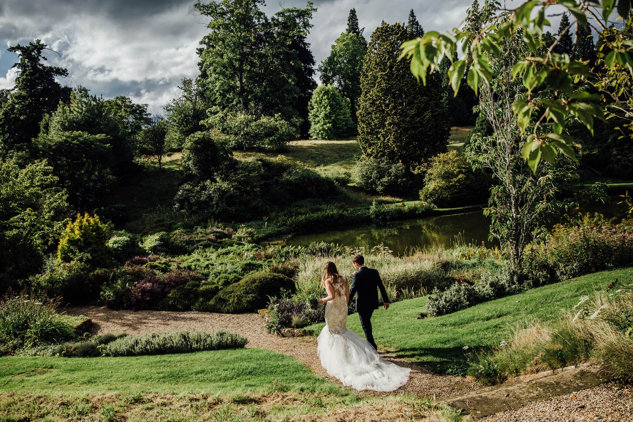 bride and groom walking into distance in sunlight