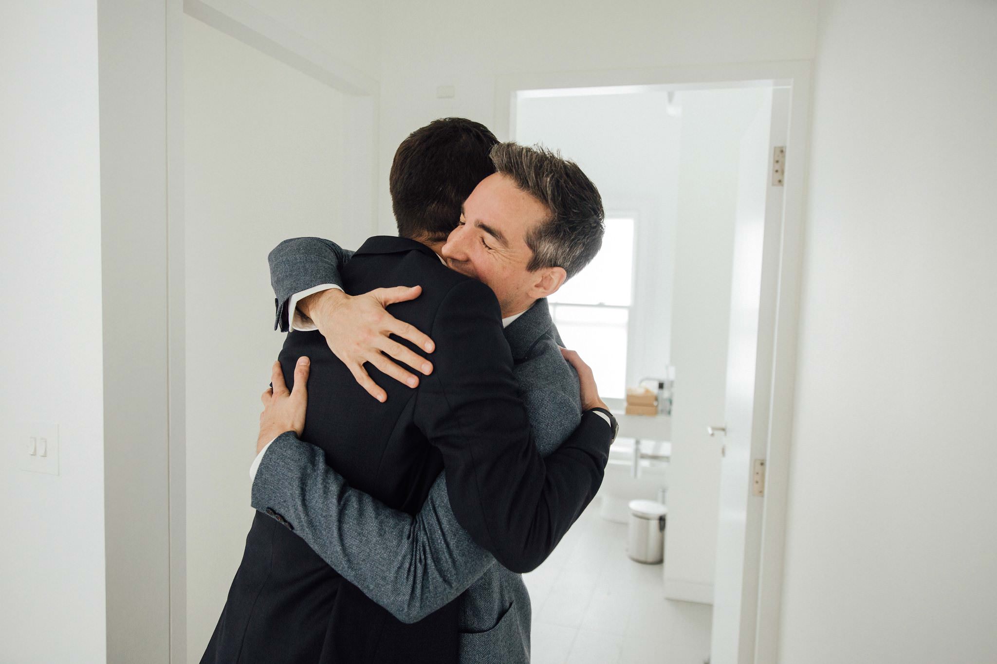 same sex wedding two grooms hugging