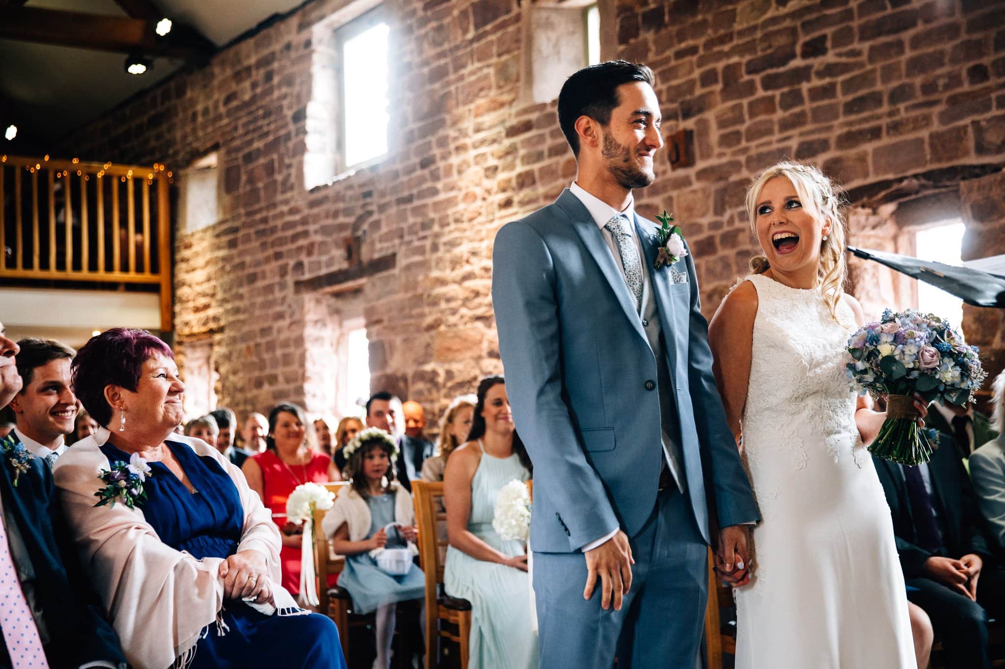 bride and groom laughing during wedding ceremony