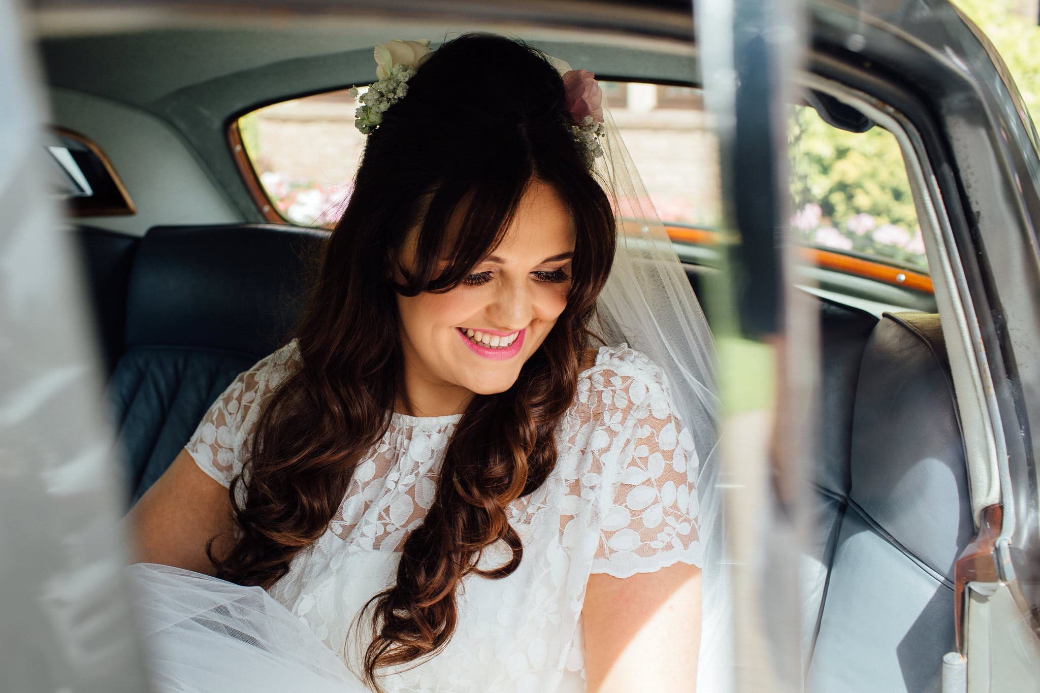 smiling bride in wedding car