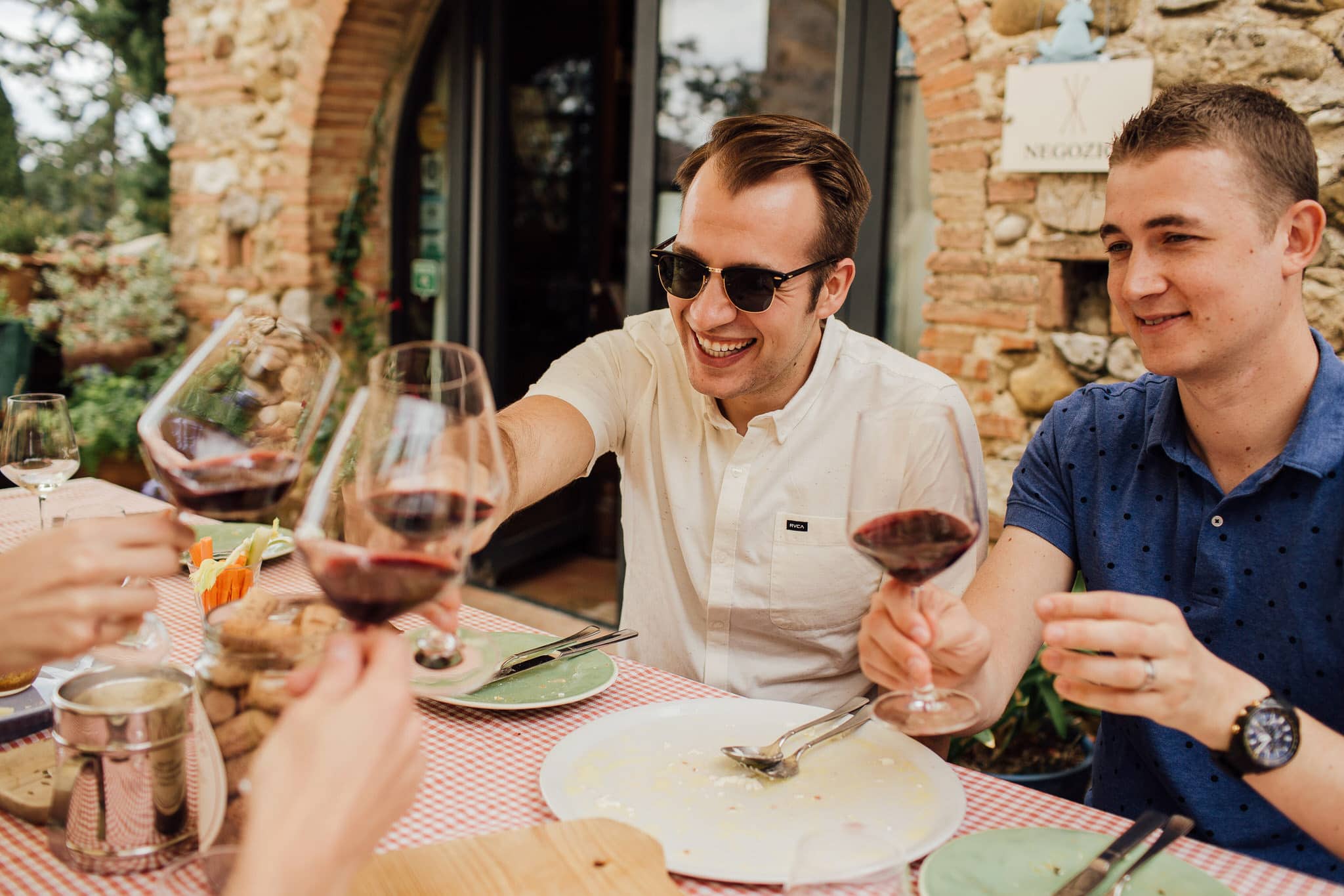 groom and ushers cheers after wine tasting for Italian wedding