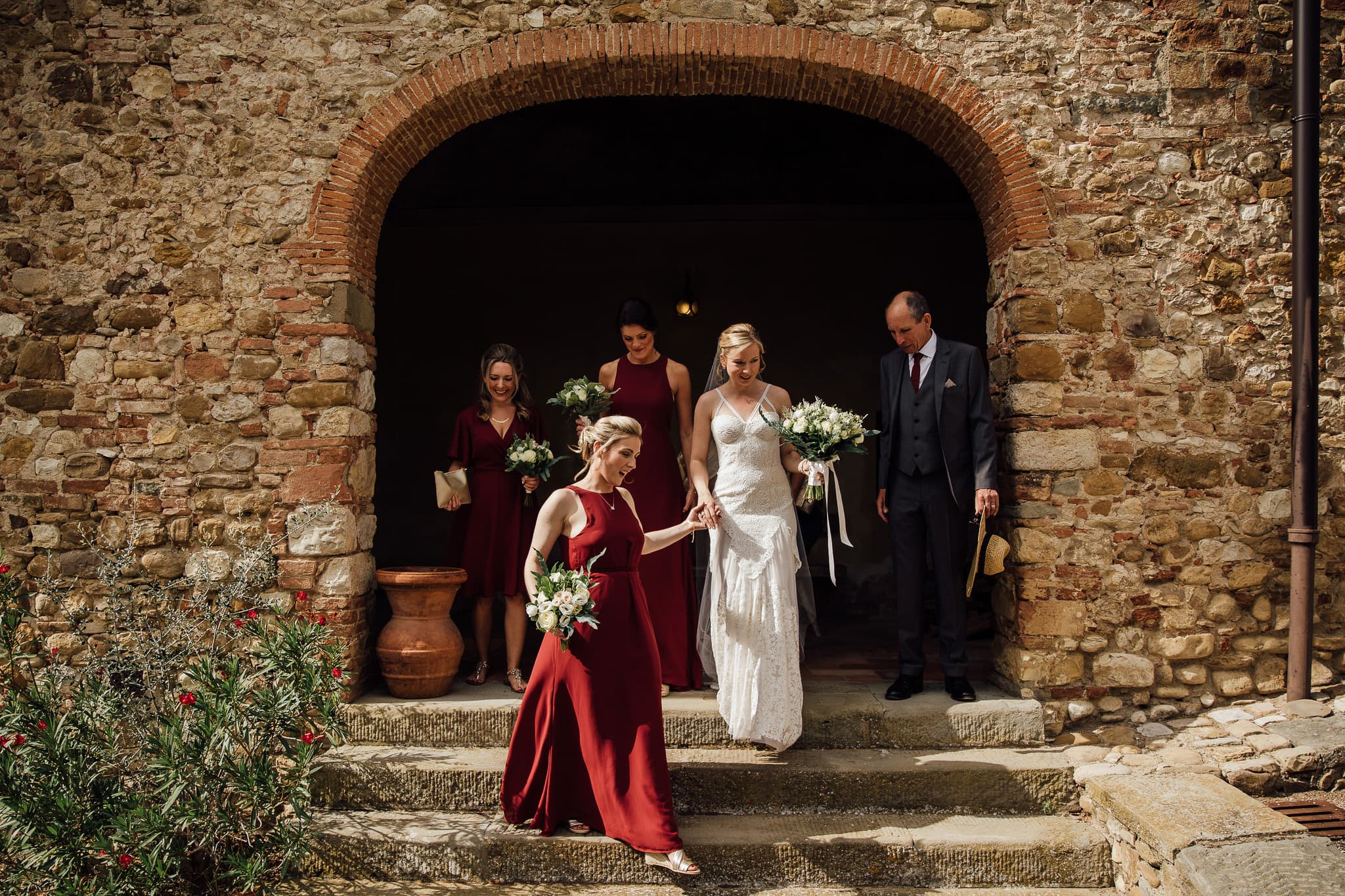 Bride and Bridesmaids in archway of Castello at wedding in Tuscany