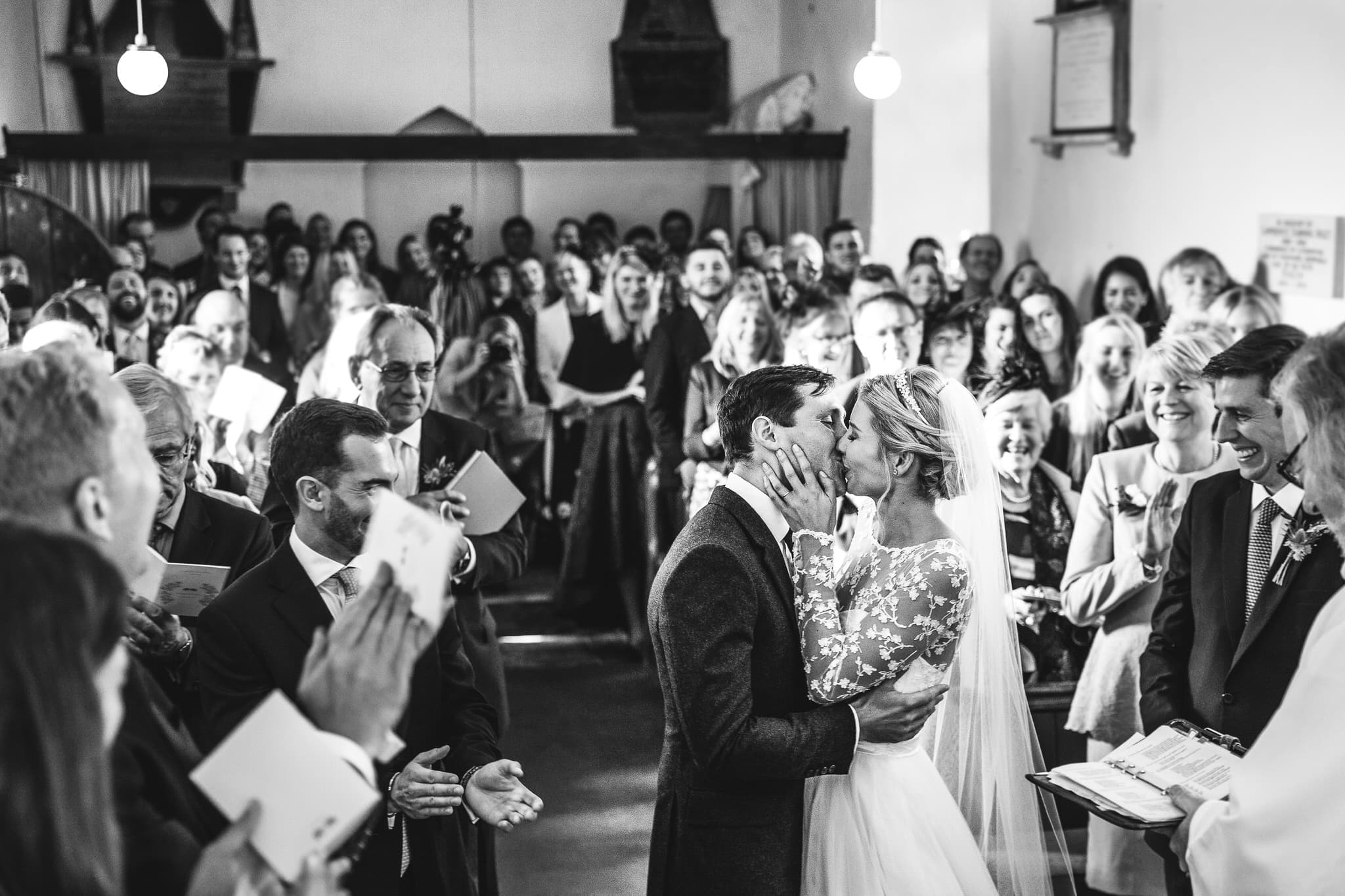 Dewsall Court wedding photographer captures first kiss in black and white