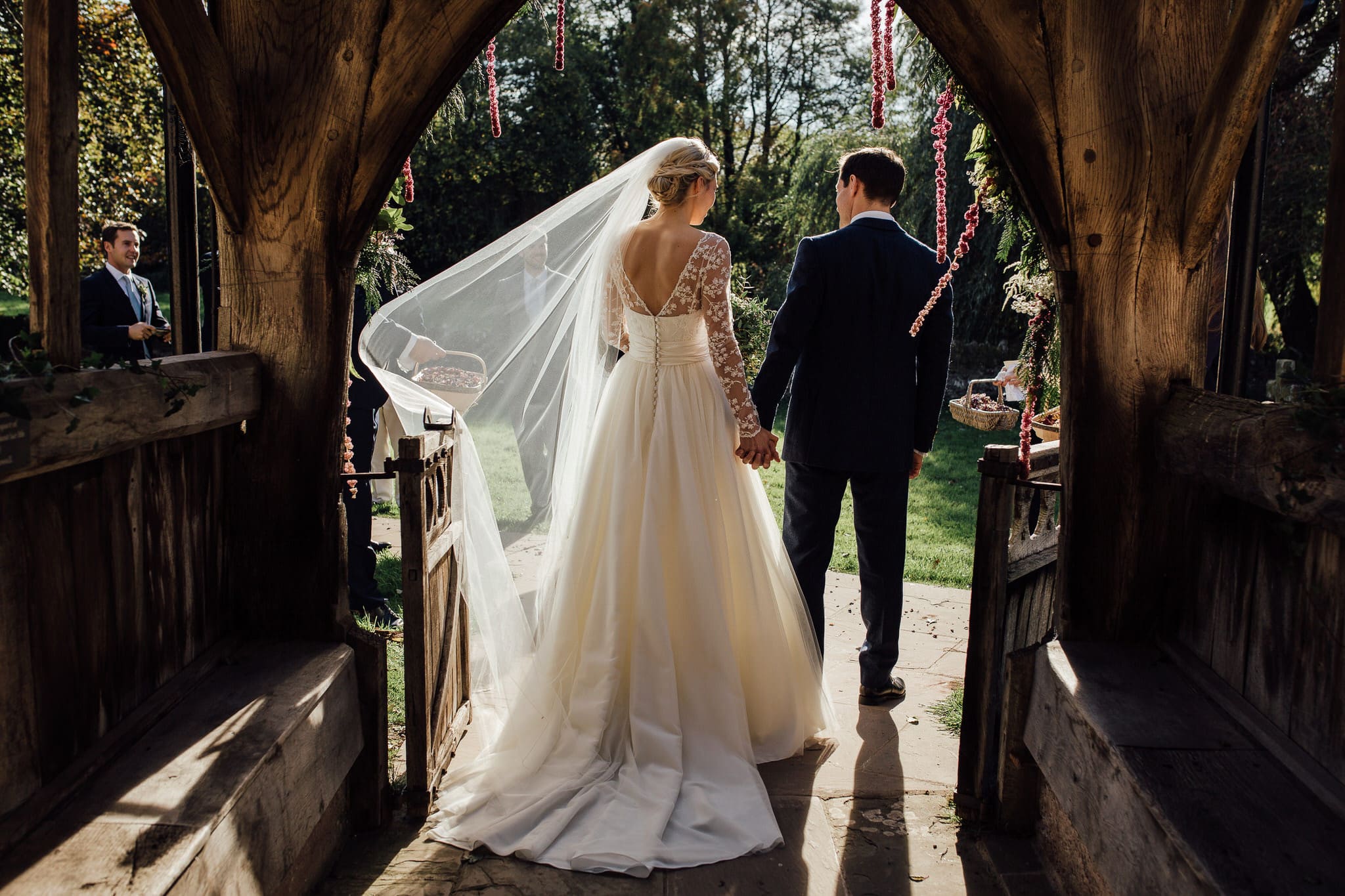 beautiful natural light as bride and groom leave the church at Dewsall Court