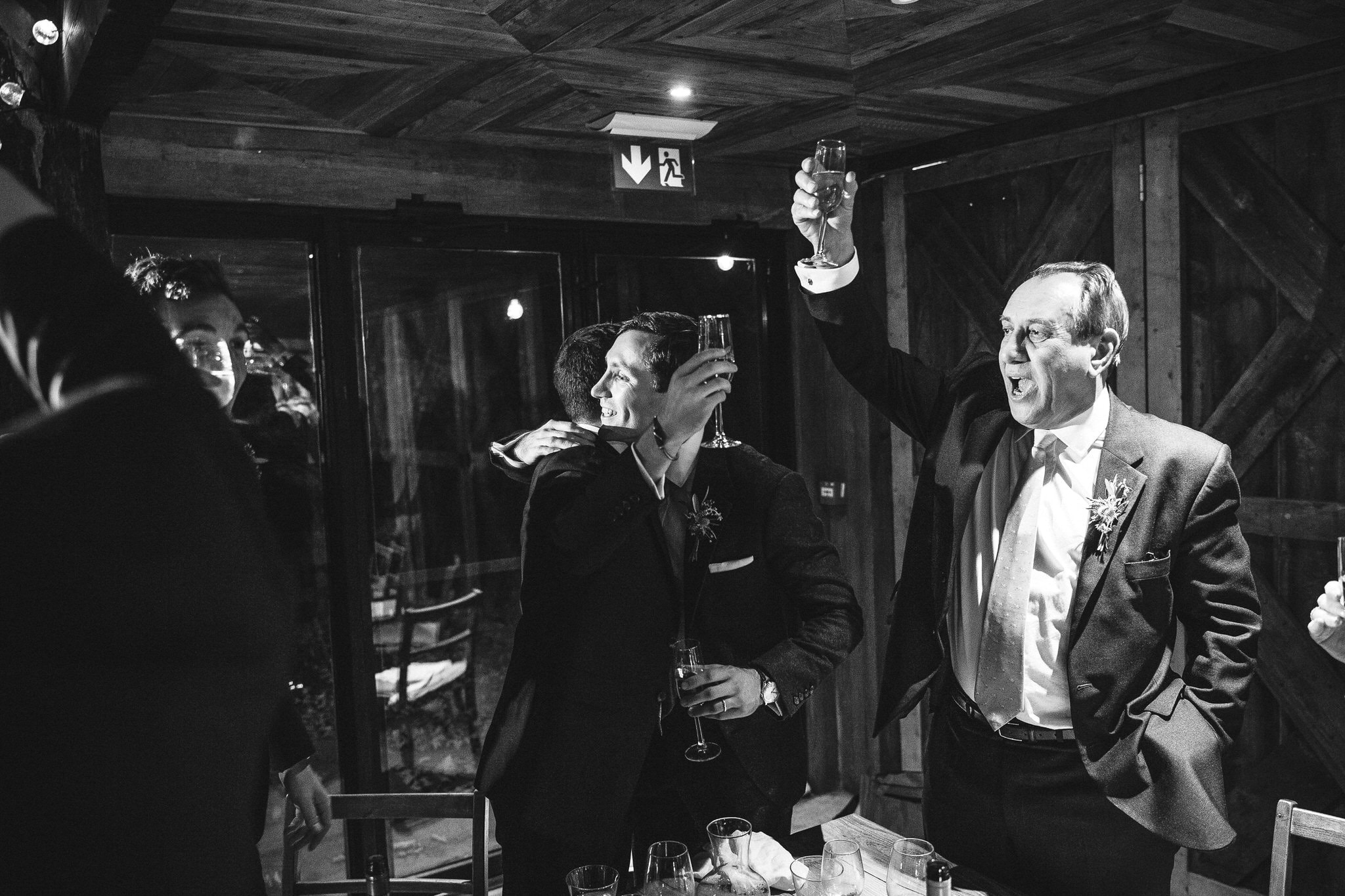 black and white image of father of the bride saying cheers