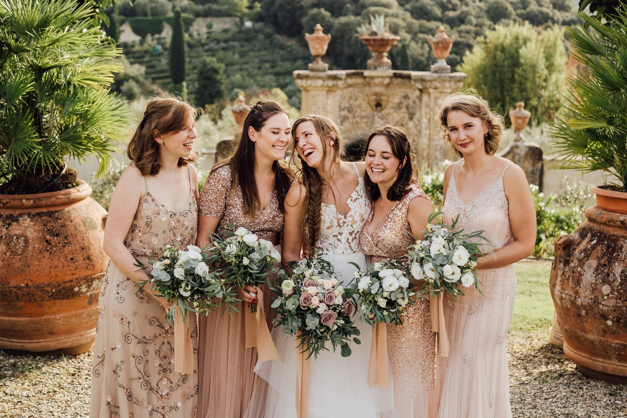 bride in tulle and lace gown and bridesmaids in rose gold dresses