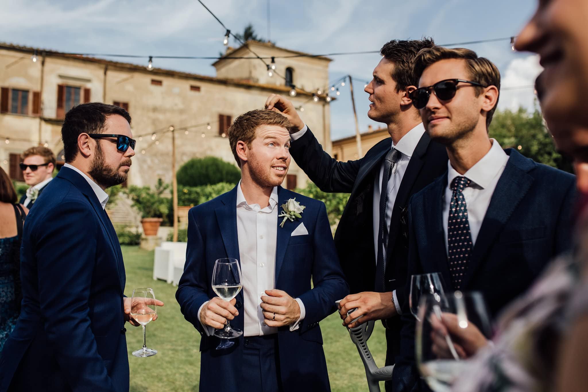 friend caught on camera picking confetti out of the groom's hair