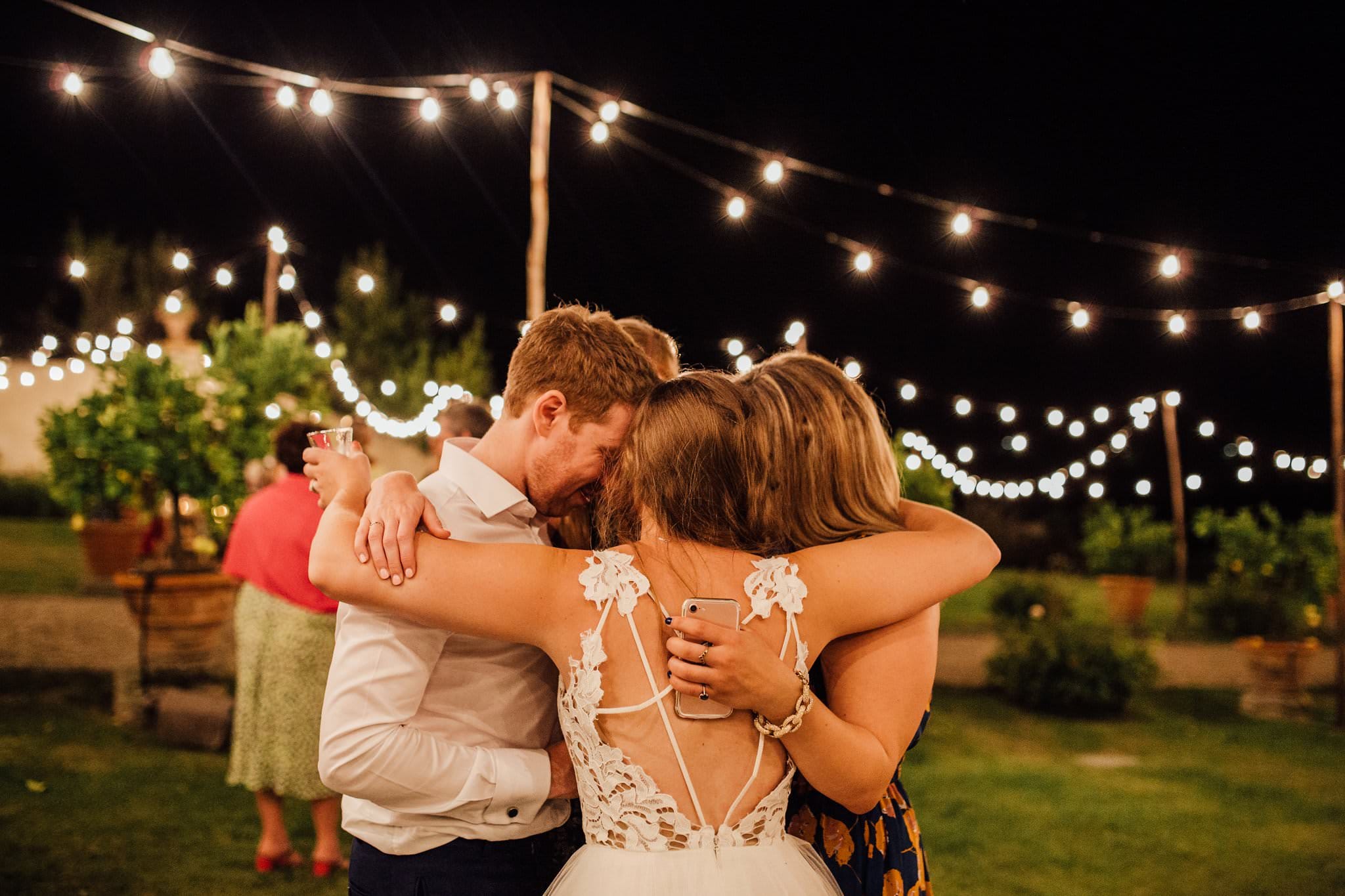 shot of bride and groom hugging best friends