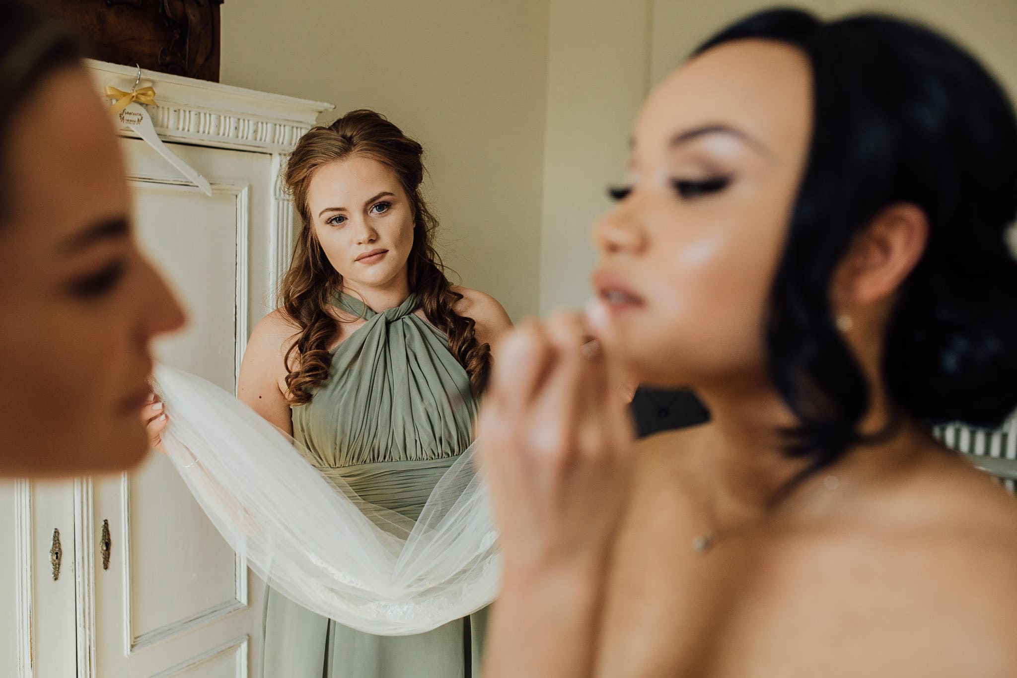 bridesmaid sage green dress holding veil