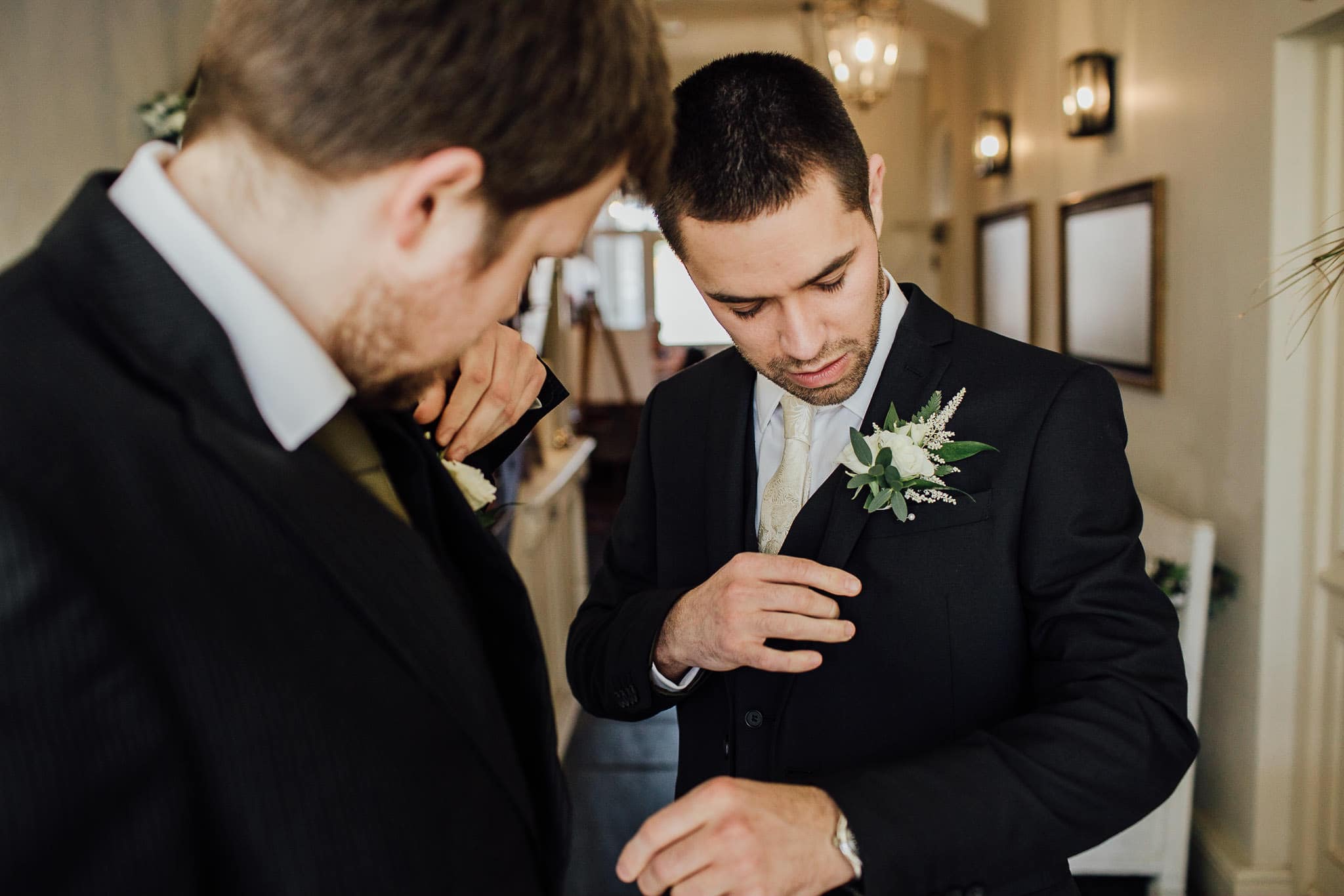 groom in navy suit with white button hole