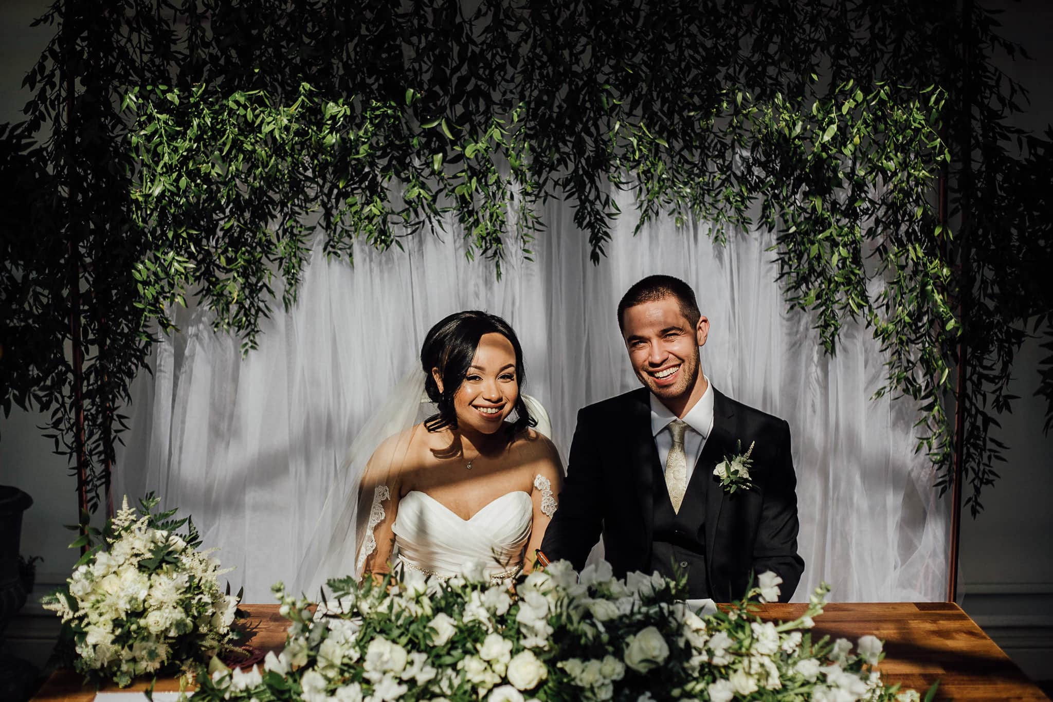 bride and groom signing the register greenery and white flowers