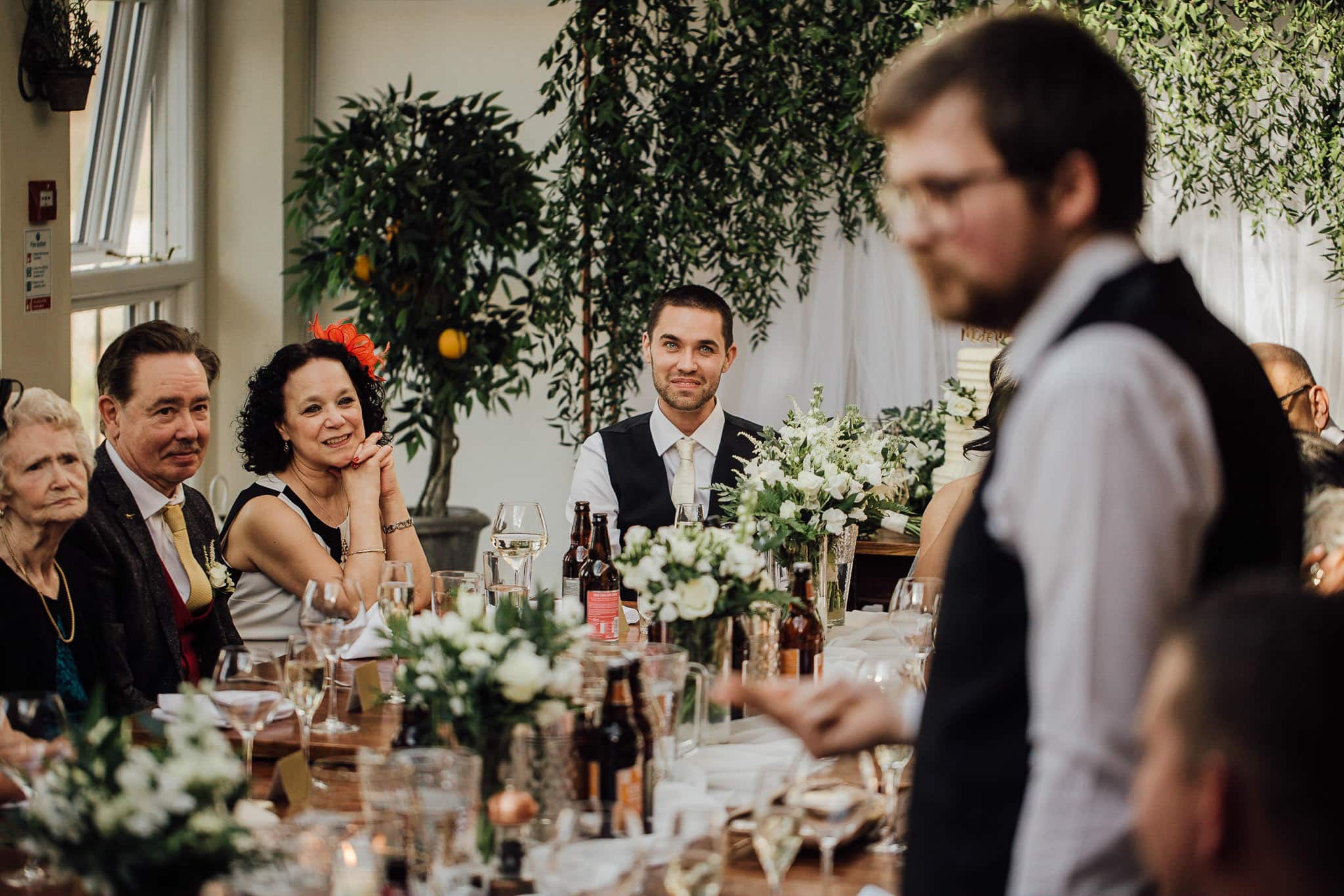 wedding breakfast room decorated with orange trees and greenery