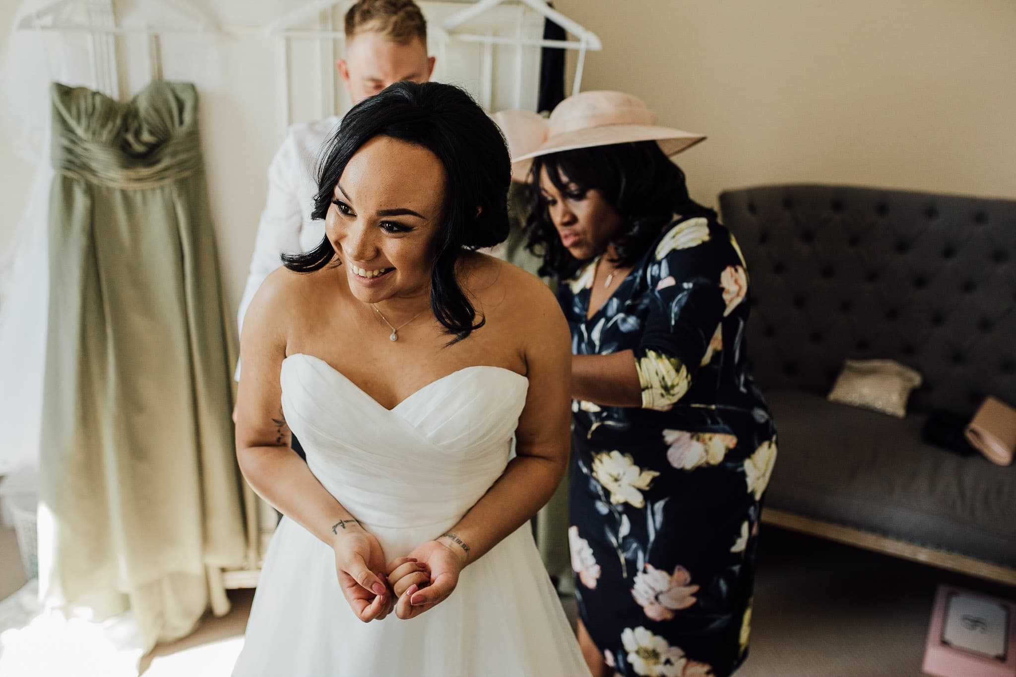 bride's mum helping put on wedding dress