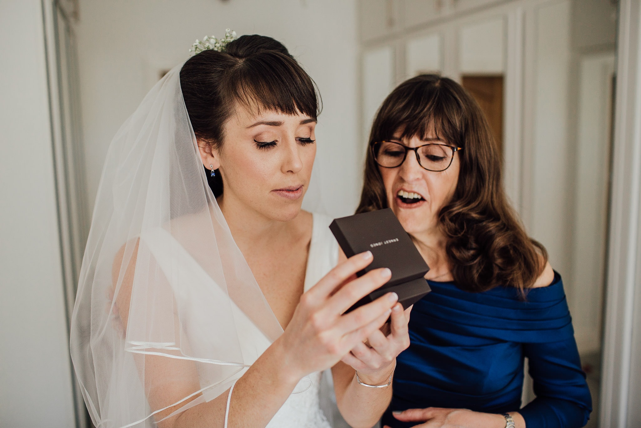 bride and mother of the bride opening presents on wedding morning