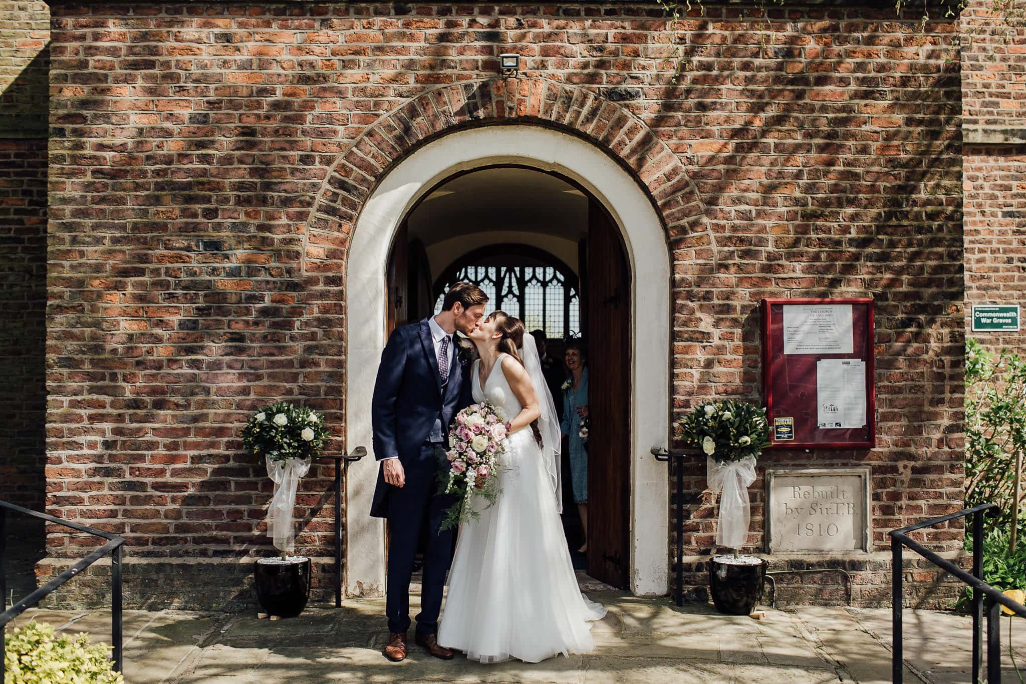 bride and groom kiss as they exit the church