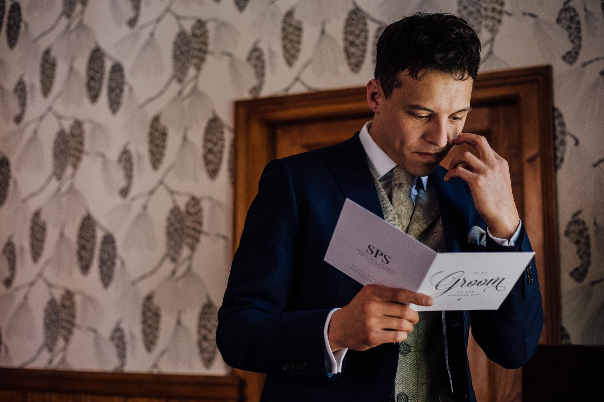 emotional groom reading card from his bride
