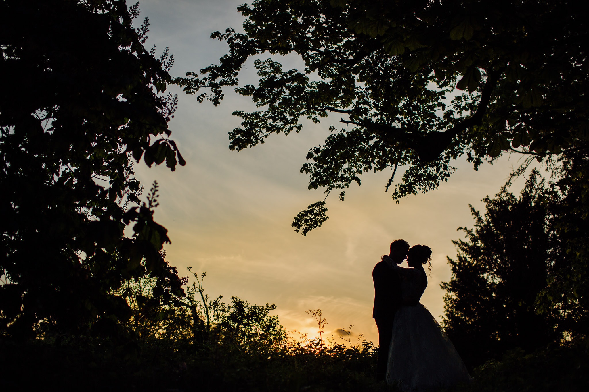 silhouette of bride and groom at sunset