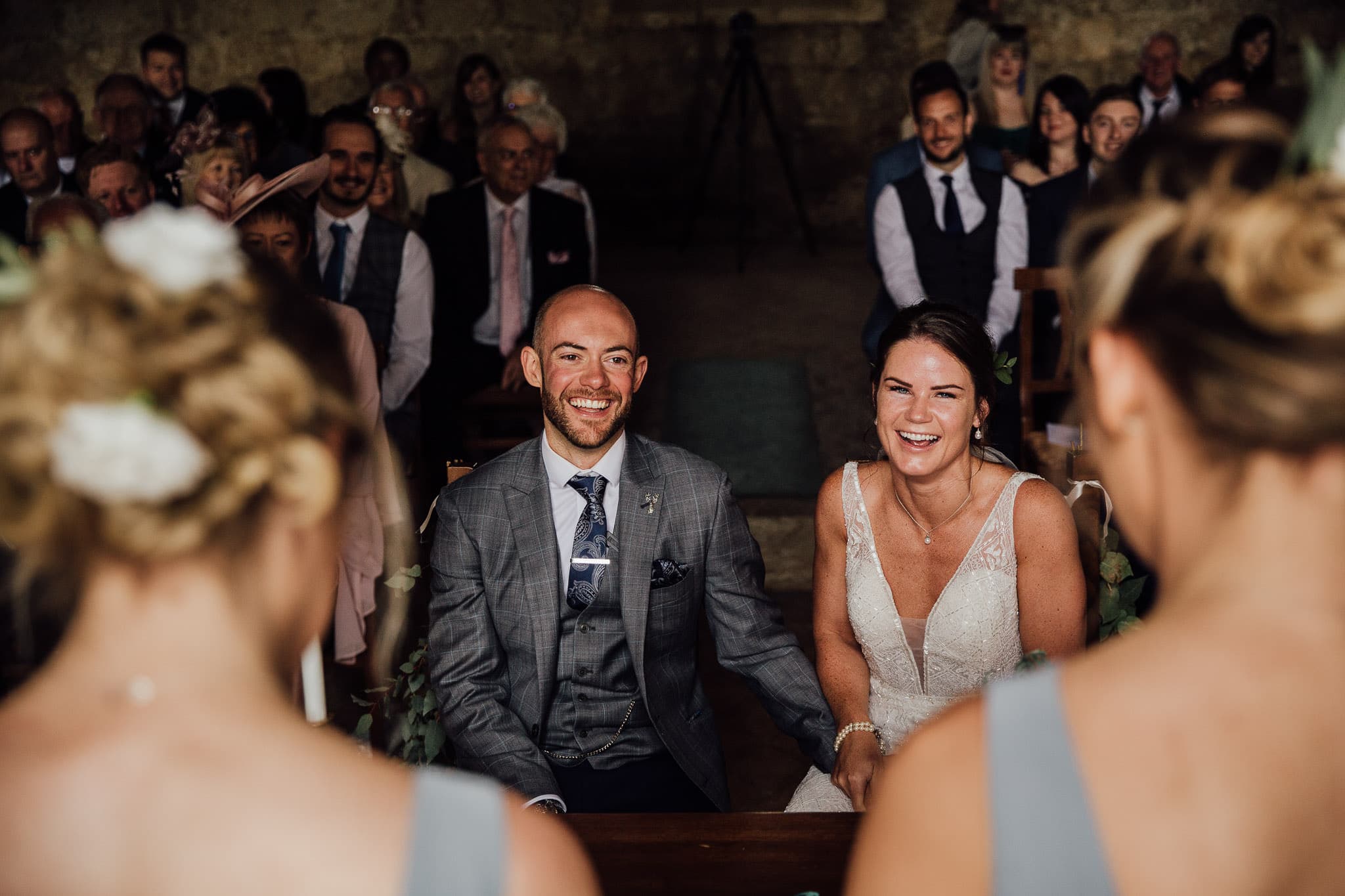 bride and groom laughing at bridesmaids' speech