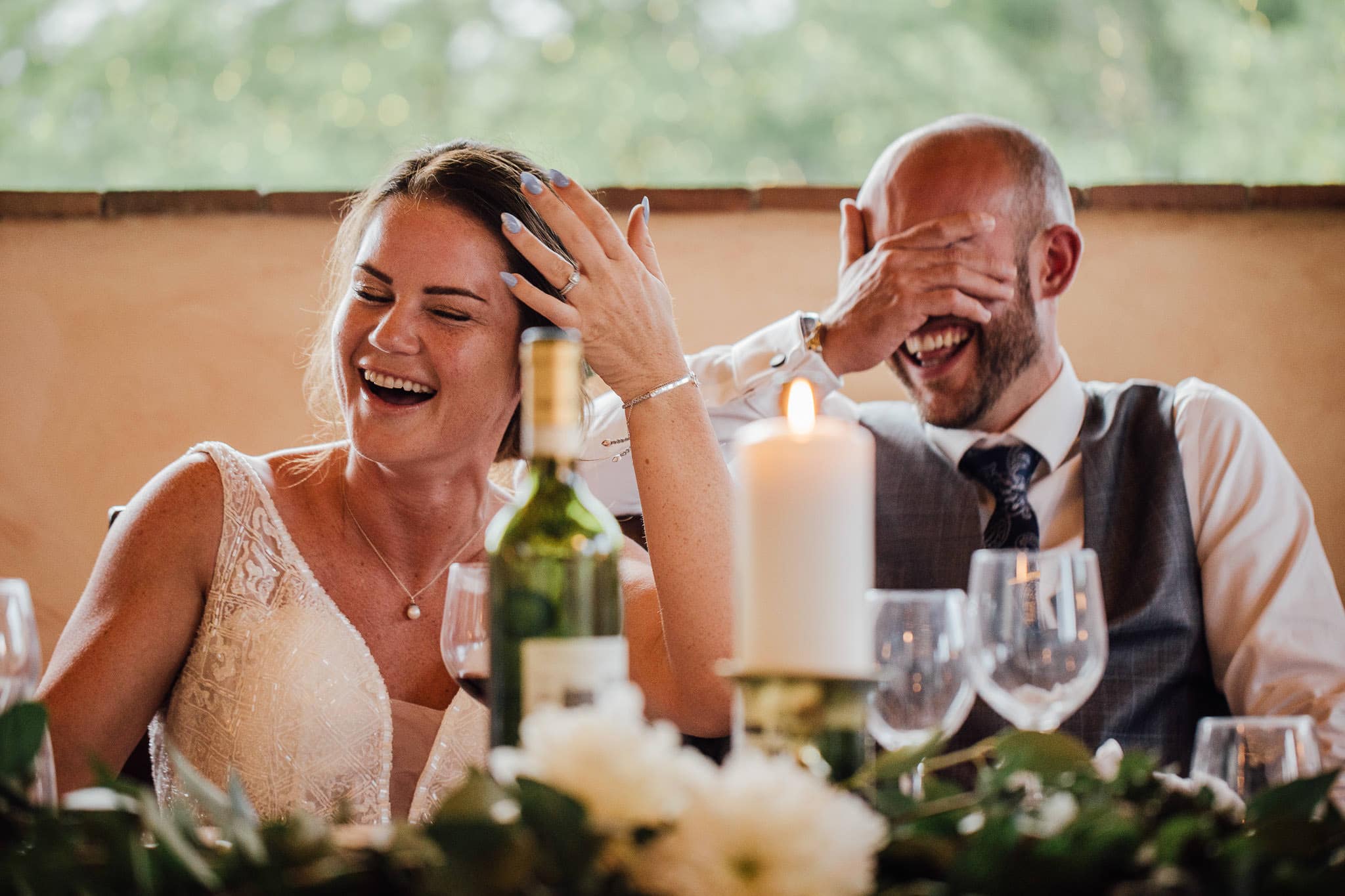 bride and groom laughing during speeches