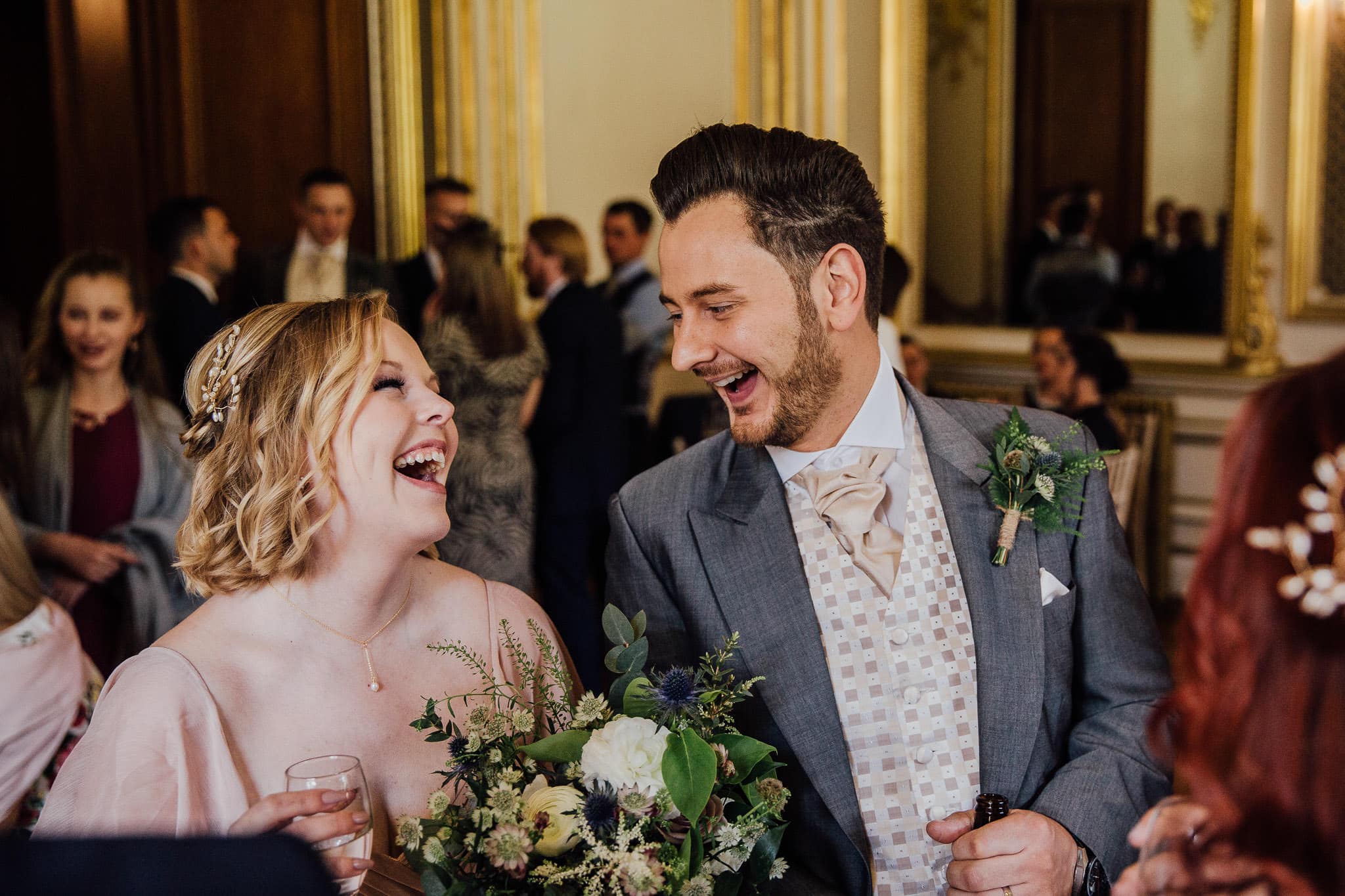 groom laughing with bridesmaid