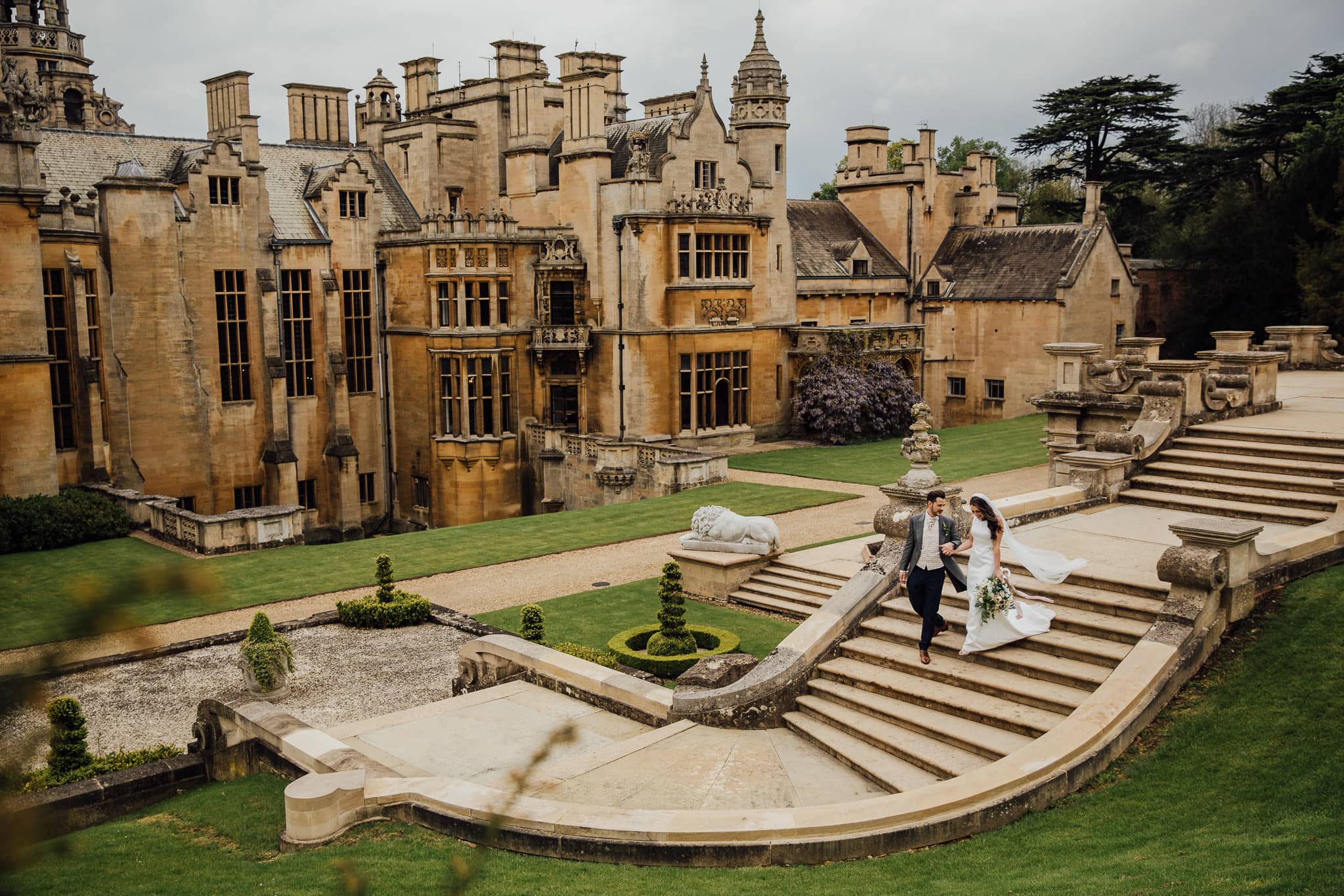 bride and groom on steps at Harlaxton Manor