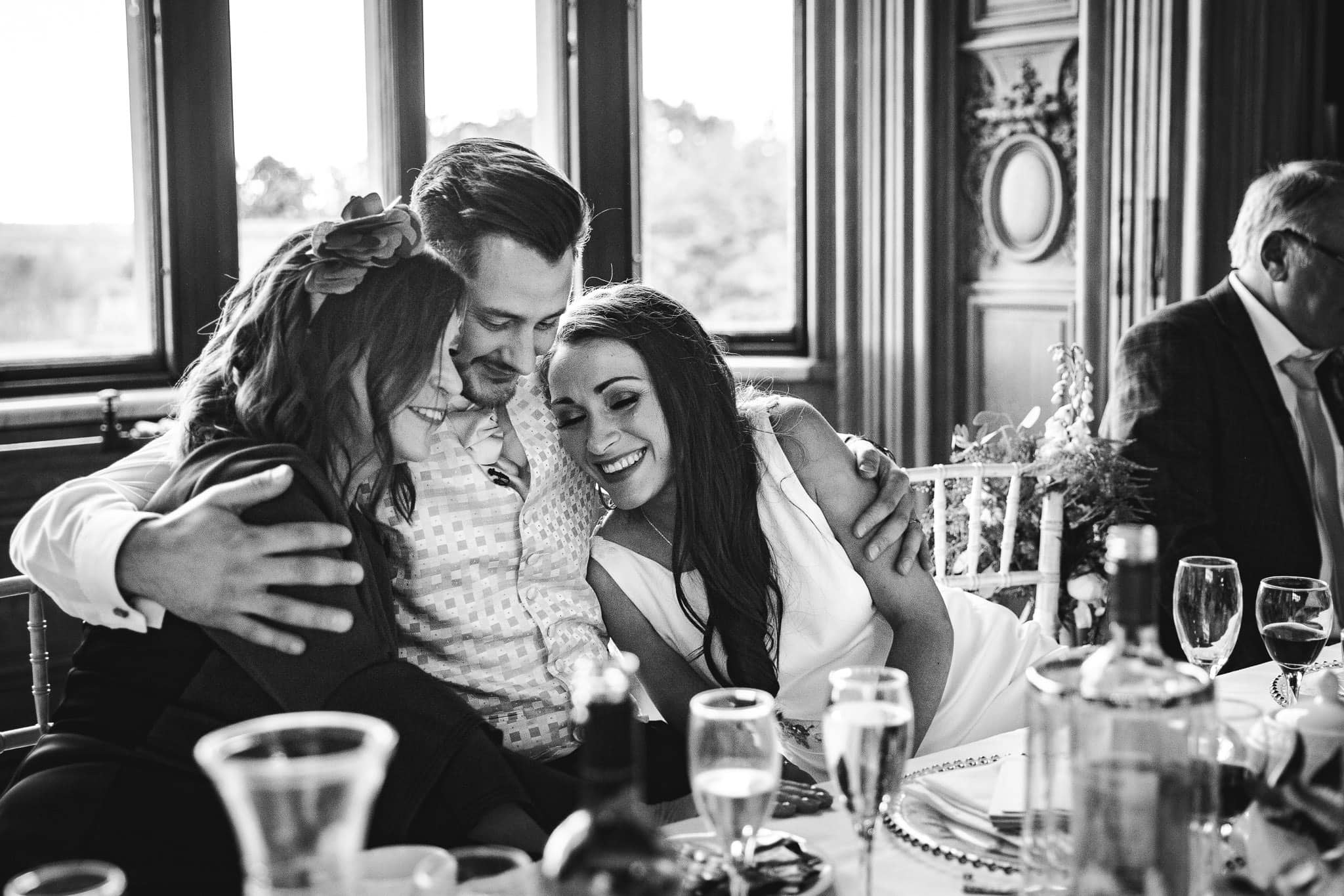 groom cuddling bride and mother of the bride