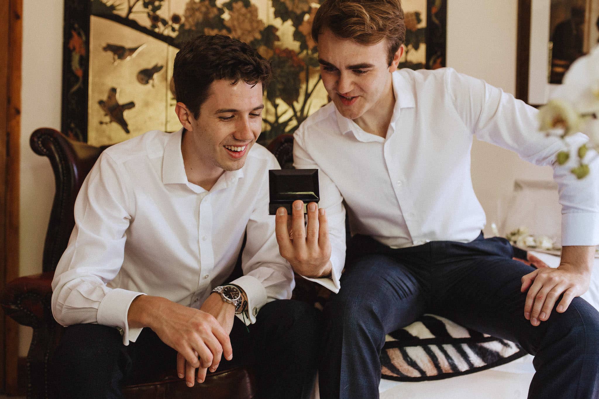 groom showing his best man the wedding rings