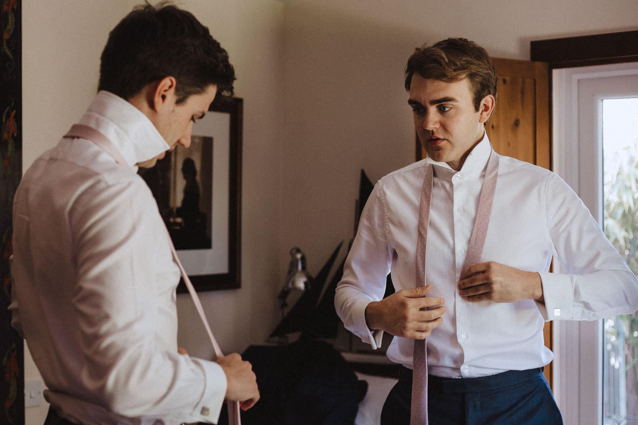 groom putting on his tie