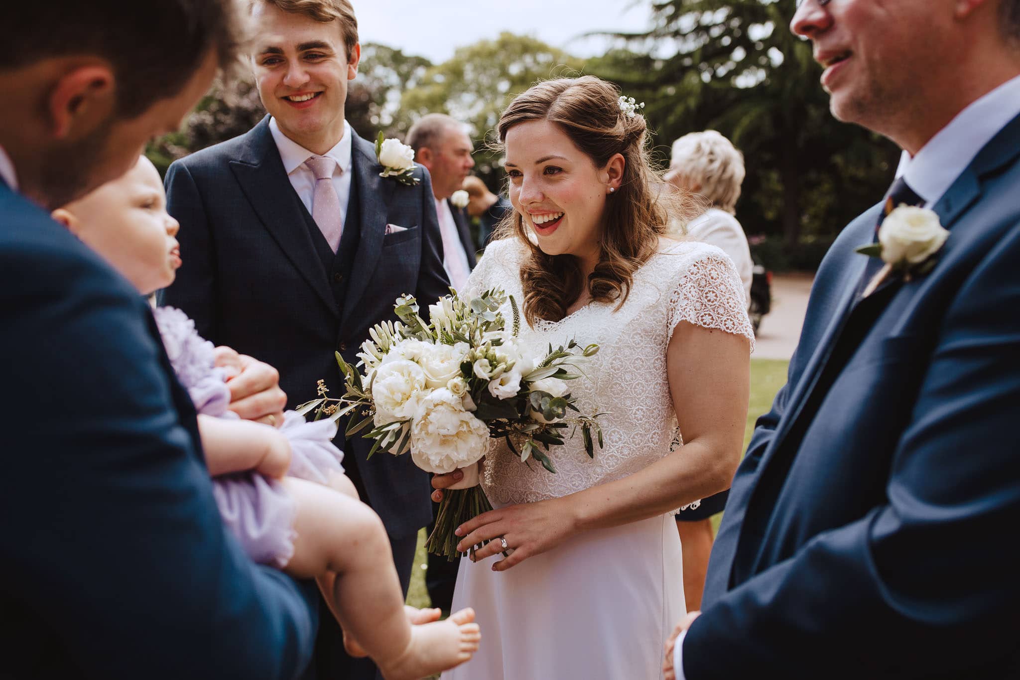 bride in lace top wedding gown with white bouquet