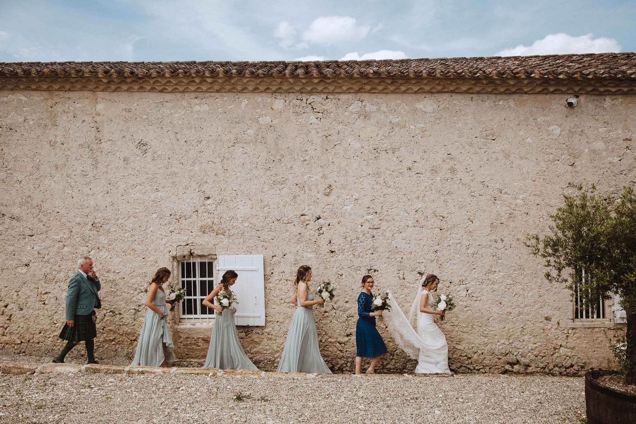 bride walking to ceremony in grounds of French chateau