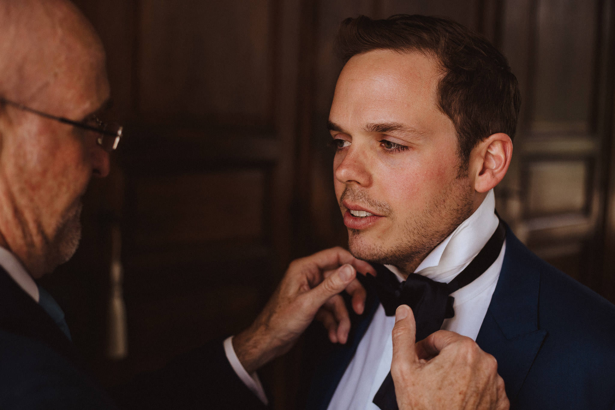 groom putting on bow tie