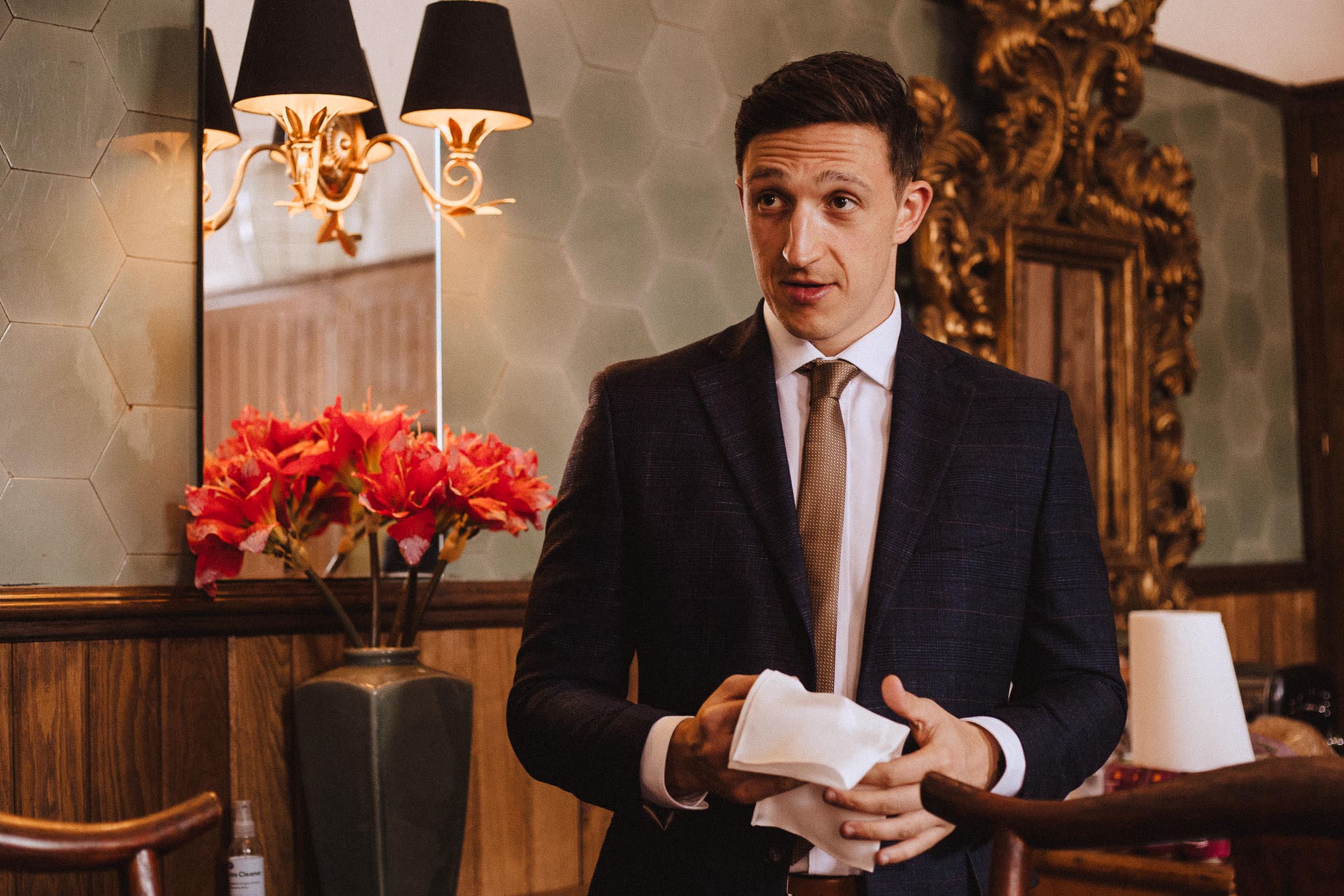 groom in navy suit and gold brown tie