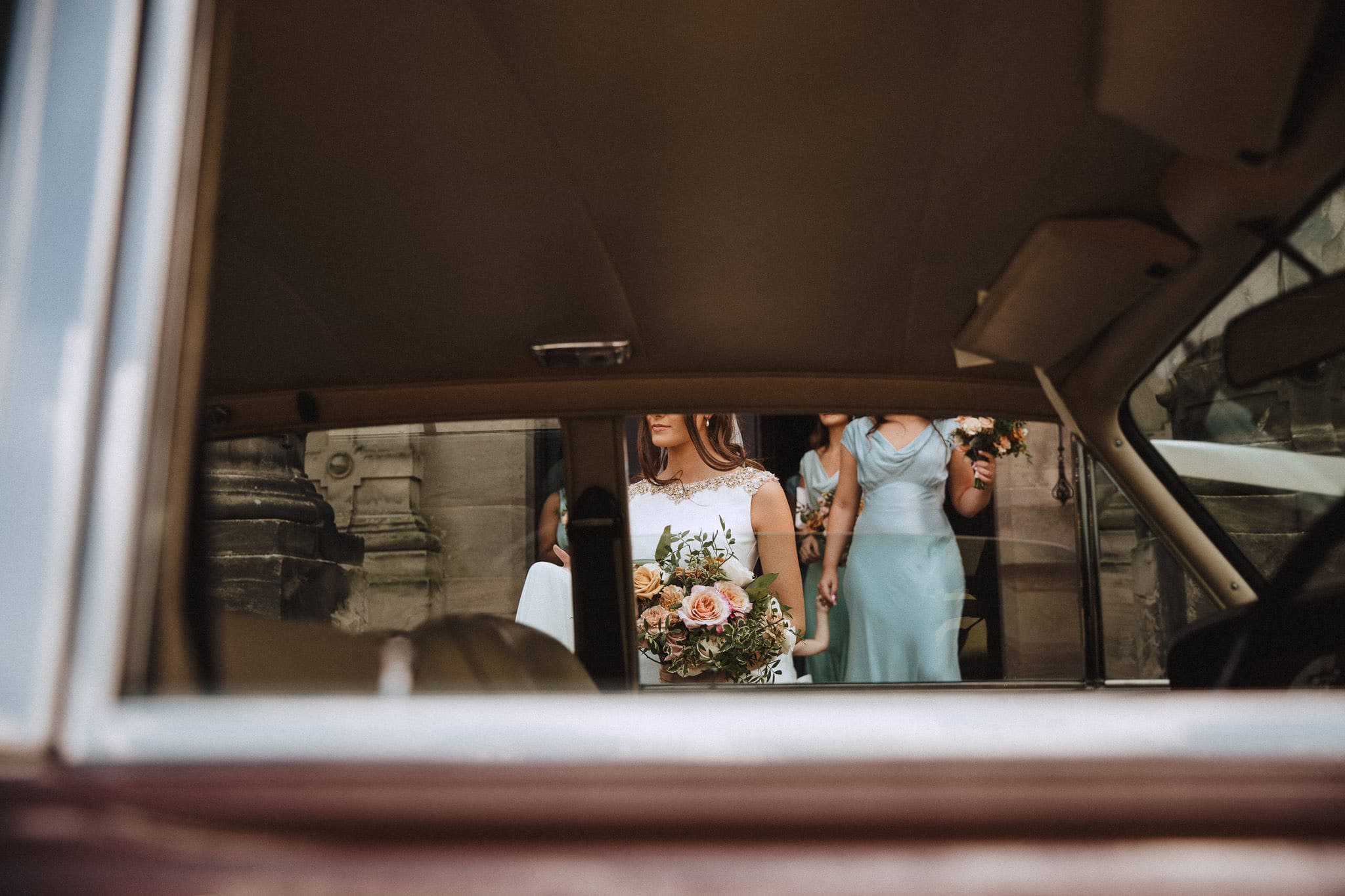 Bride captured through window of wedding car