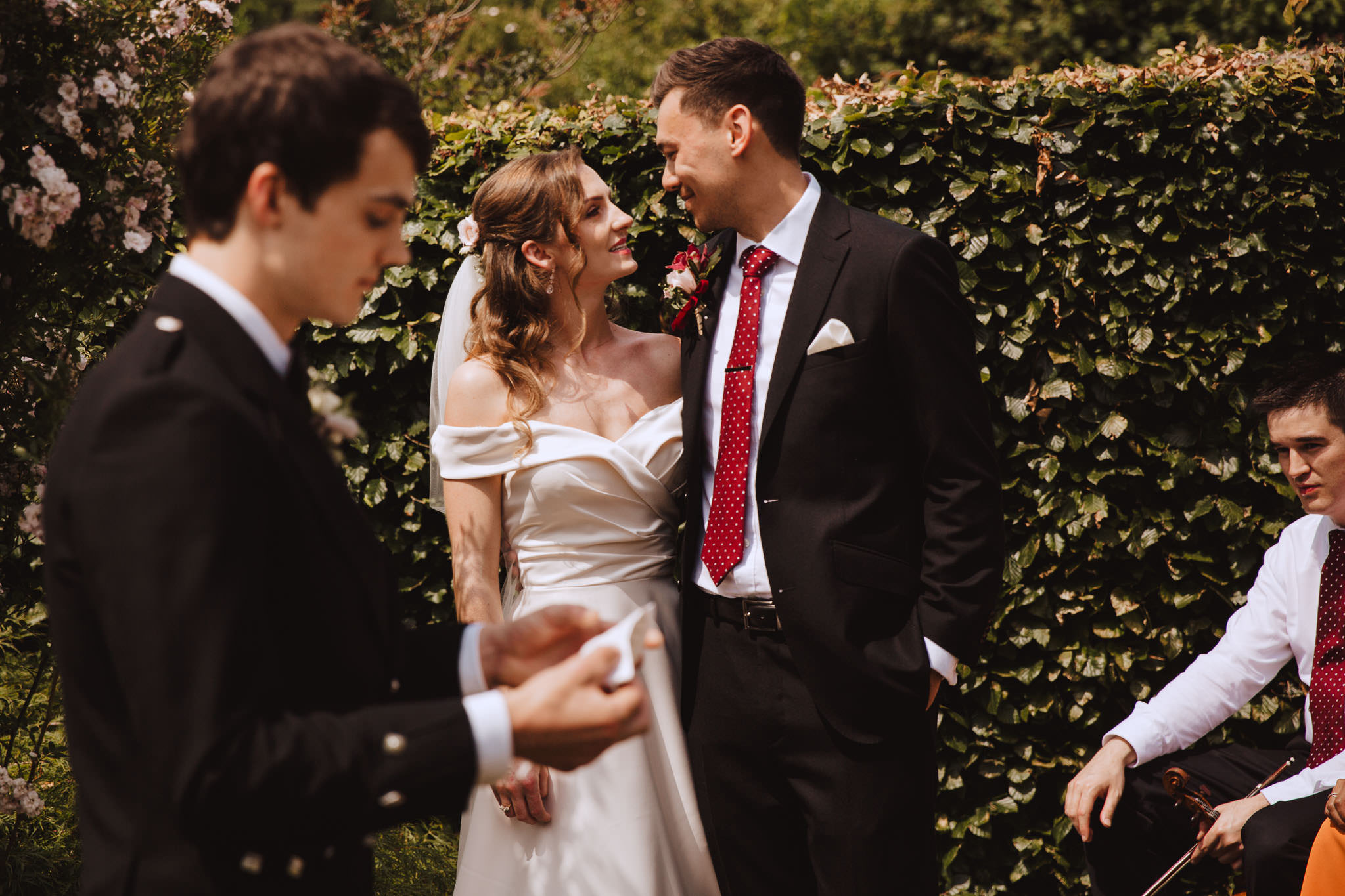 bride and groom enjoying the readings at their garden wedding ceremony