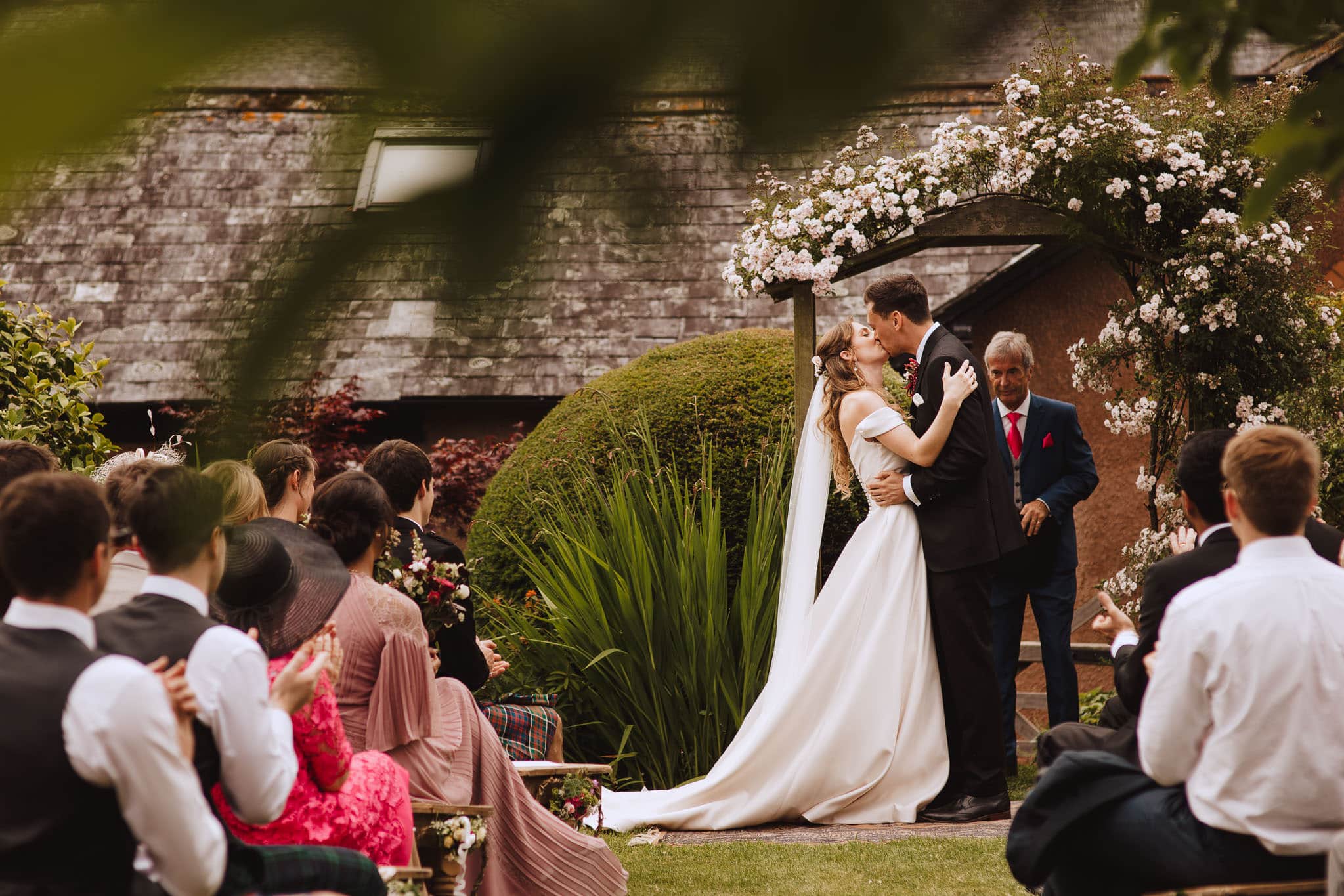 first kiss under natural floral arch