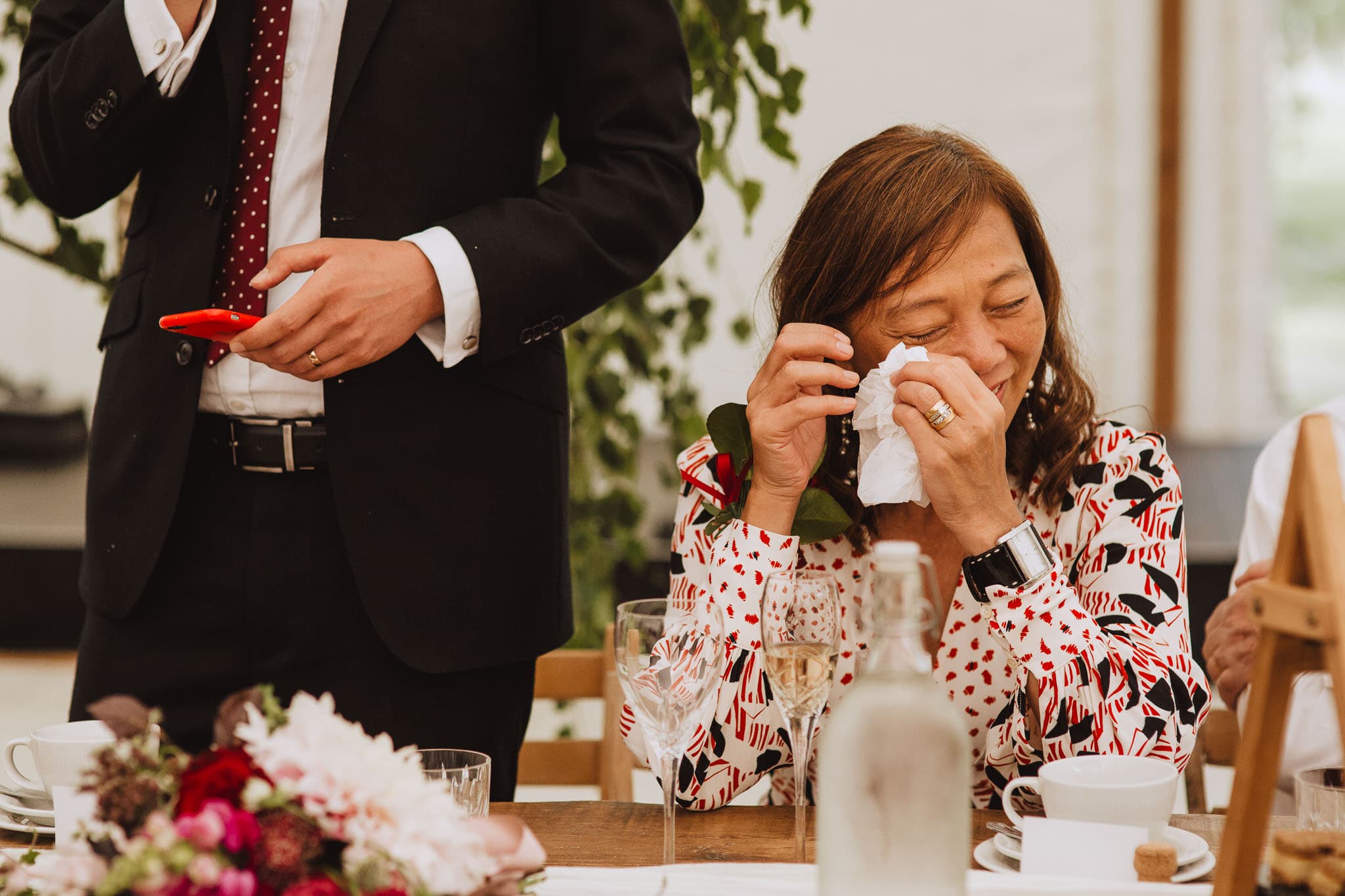 mother of the groom wiping a tear during his speech