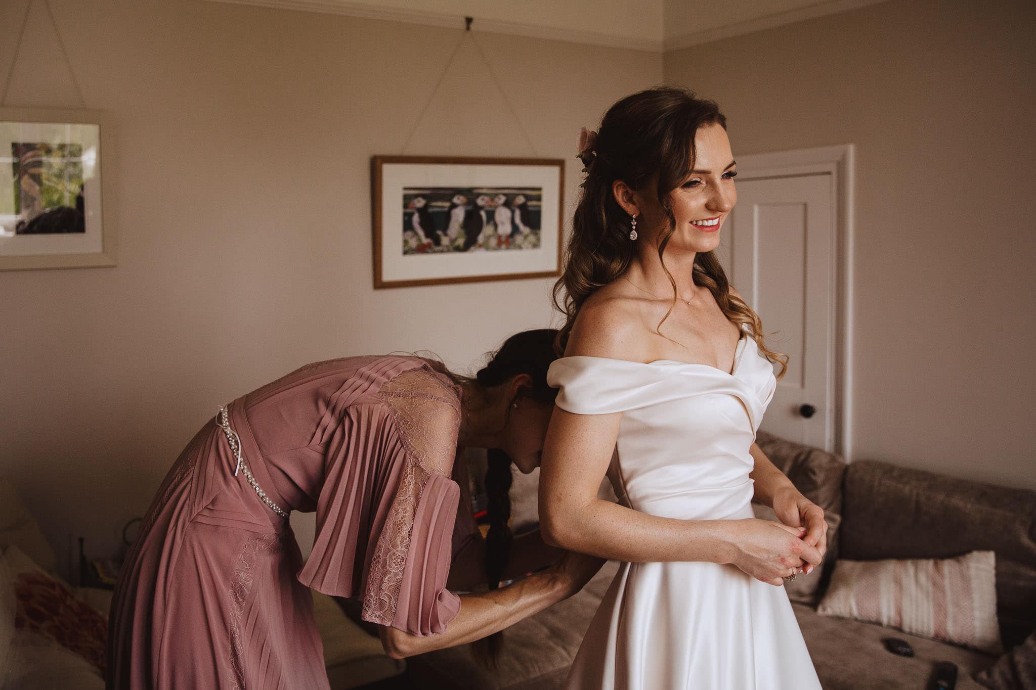 Bride putting on wedding dress for her Marquee Wedding at Home