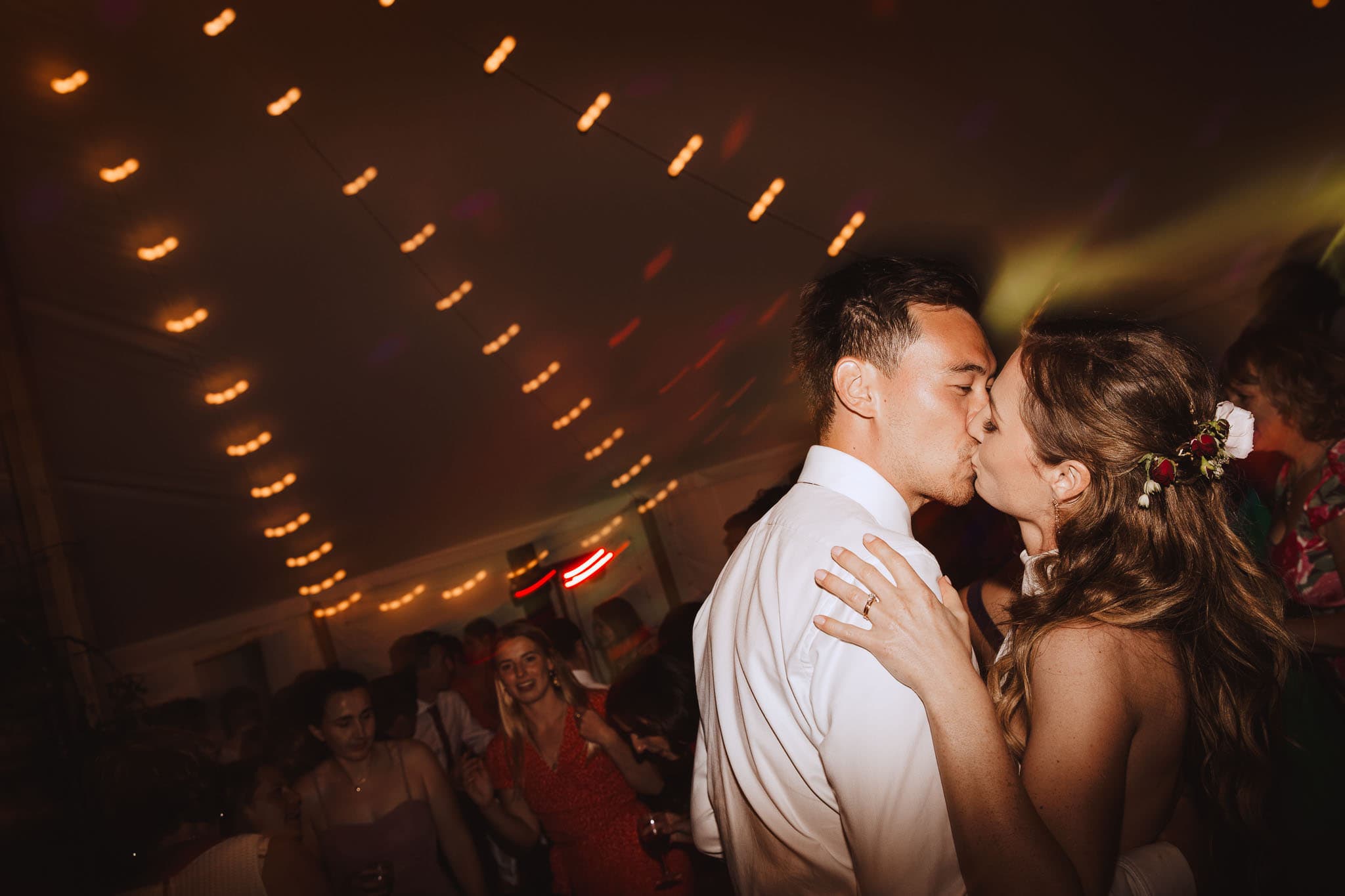 candid shot of bride and groom kissing on the dance floor