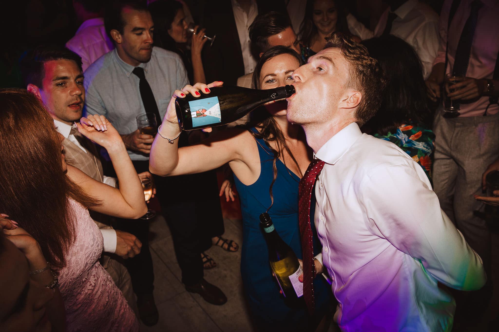 drinking champagne from the bottle on the dance floor