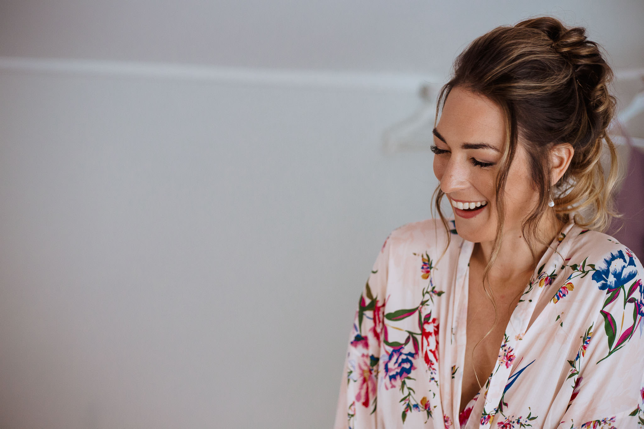 close up of bride laughing in floral dressing gown