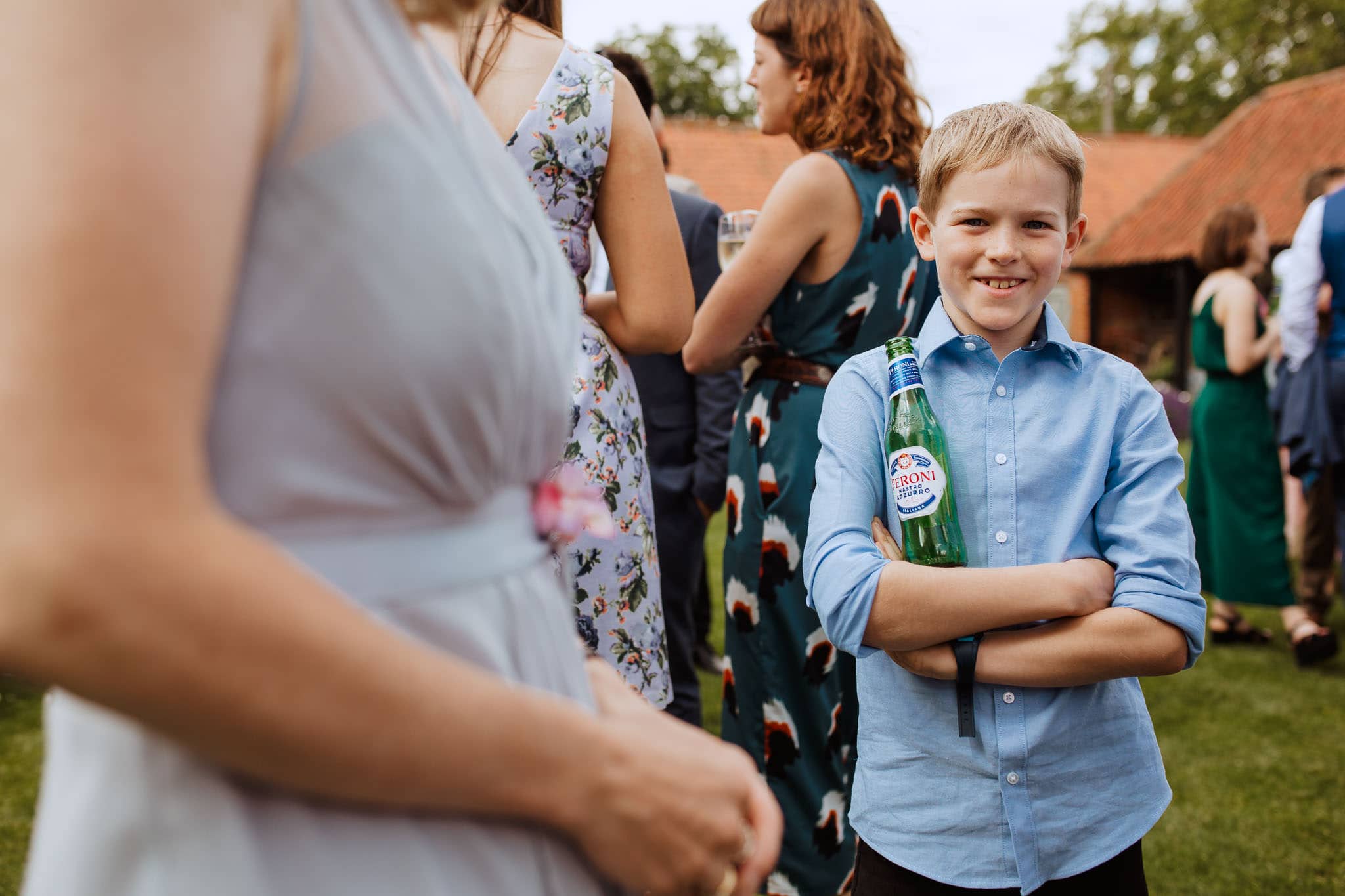 young lad holding beer at wedding drinks reception