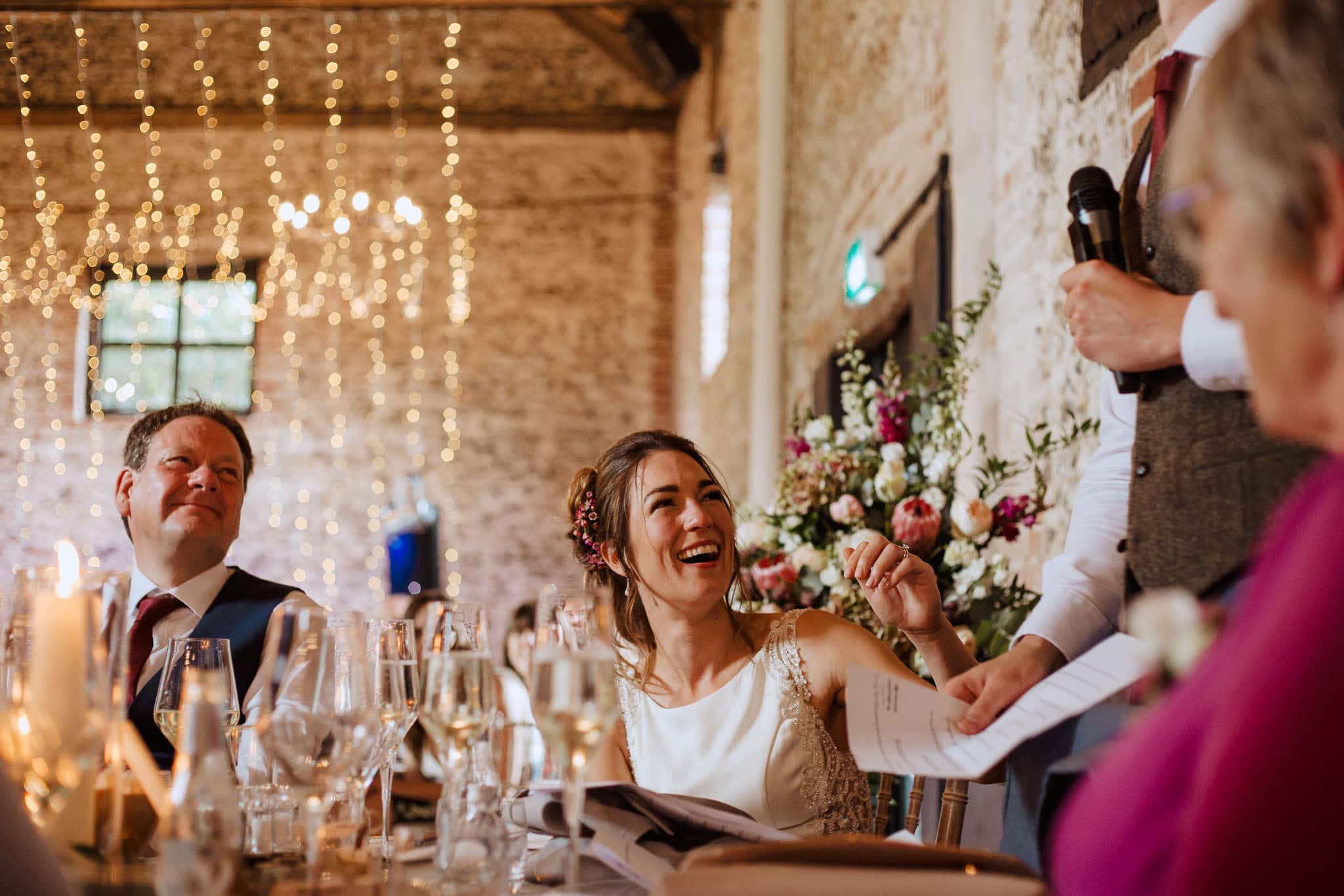 bride laughing at the groom's hilarious speech