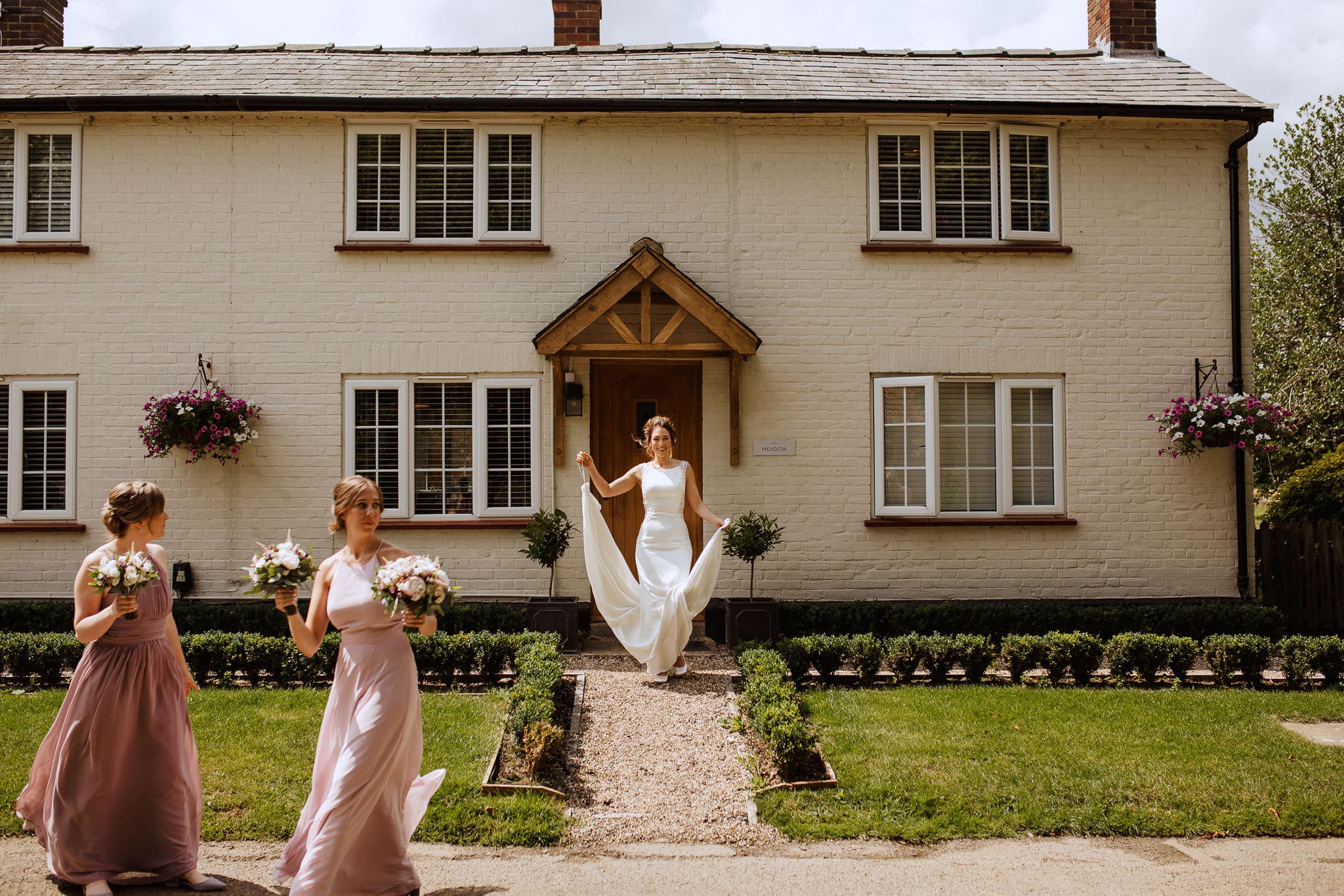 bride leaving the cottage to walk to the ceremony at The Granary Estates Wedding