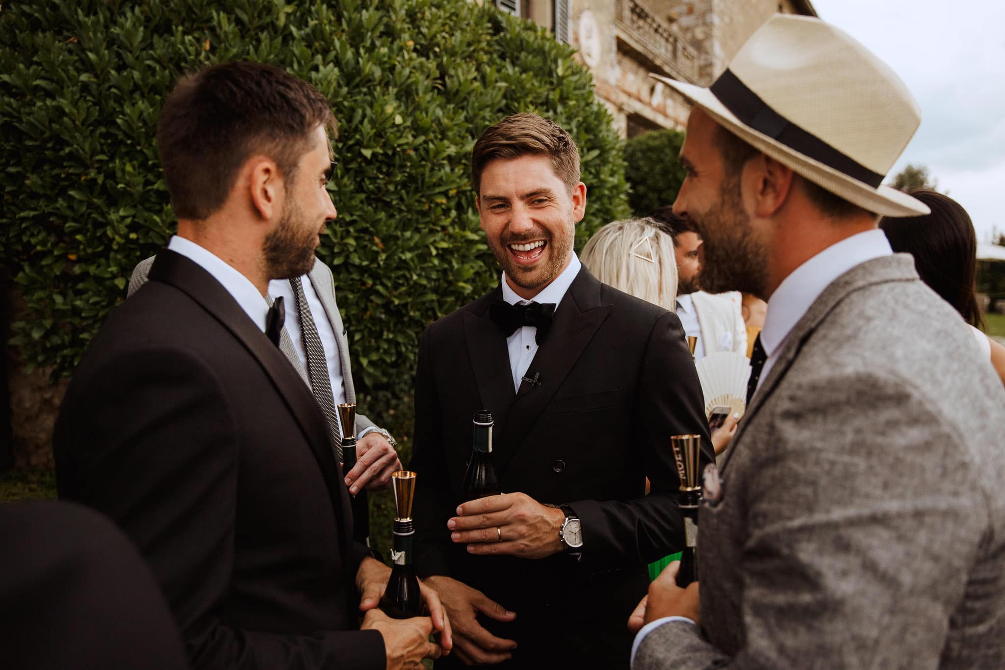 groom in black tux laughing with guests at his Italian wedding, Borgo Stomennano