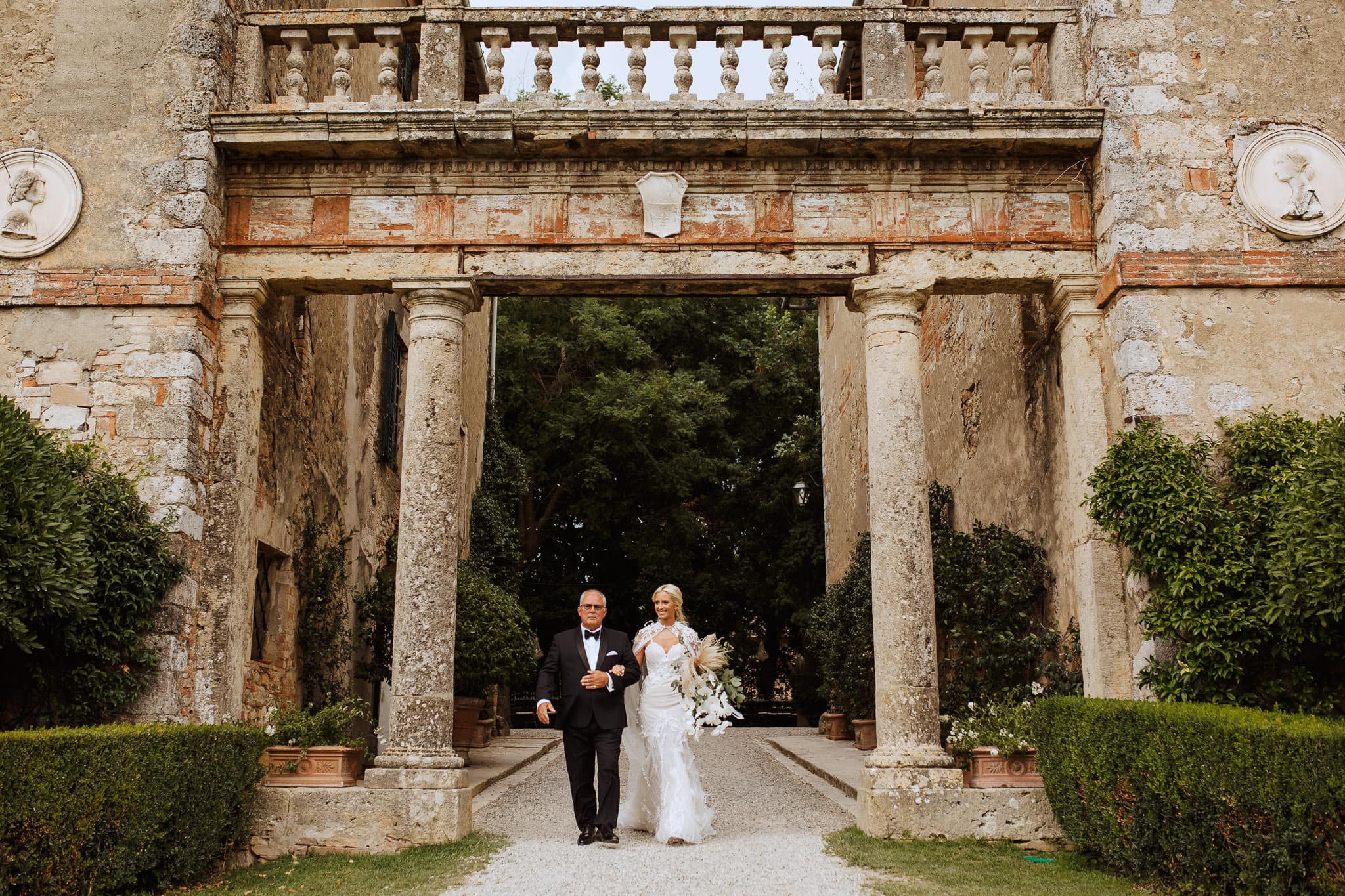 bride walking through the archway at Borgo Stomennano Wedding, Tuscany